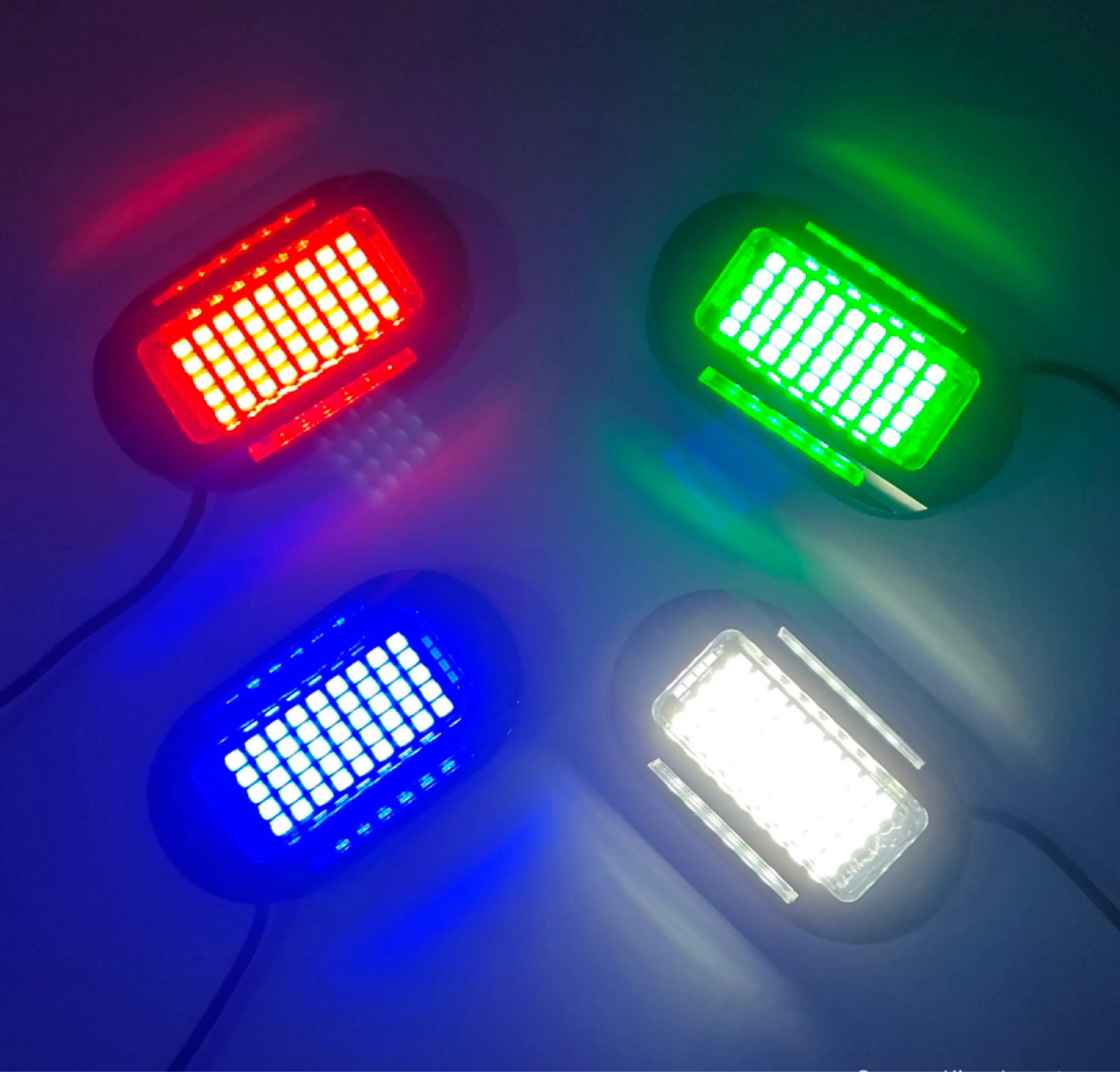 three different colored rock lights on a white surface
