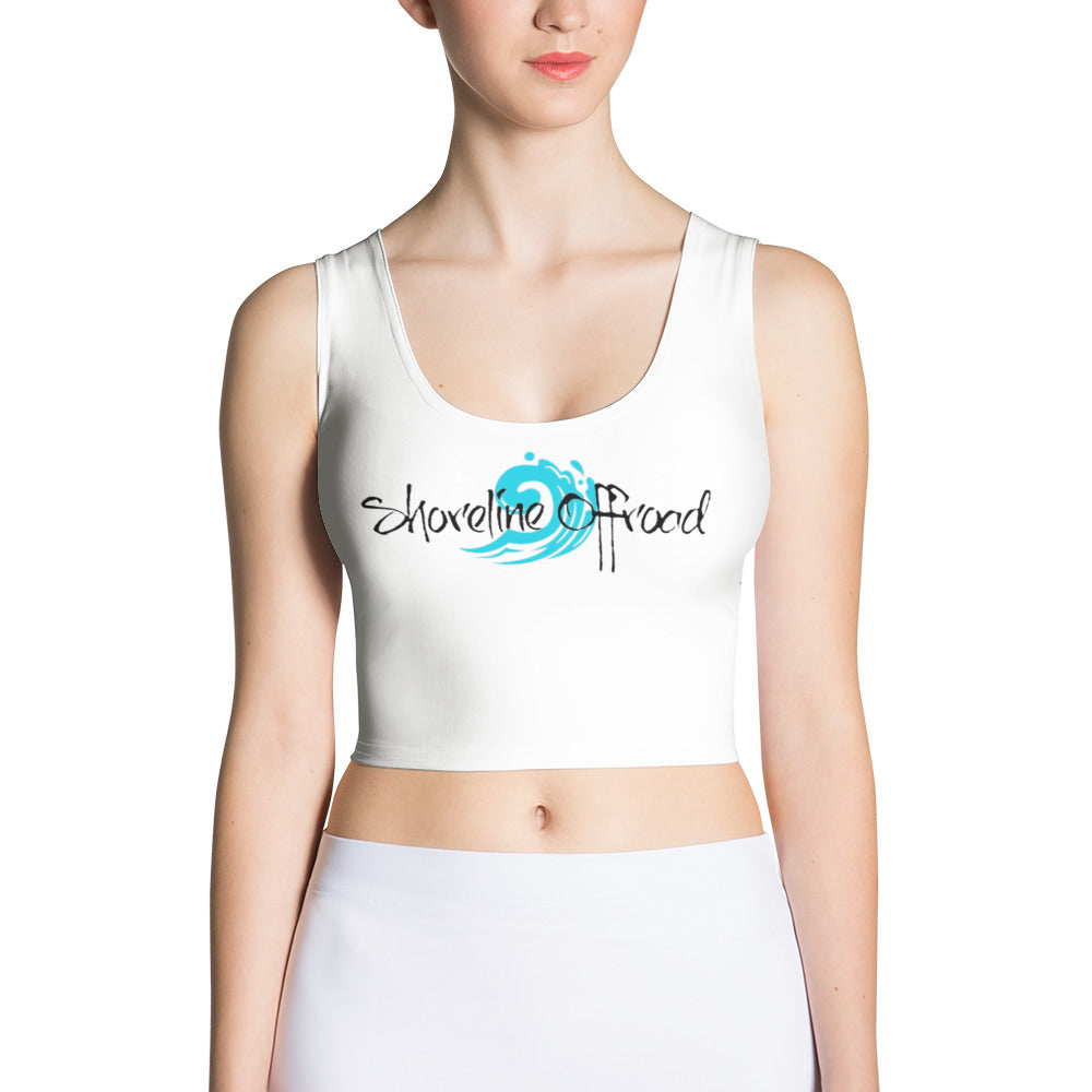 a woman wearing a white crop top with a logo on it