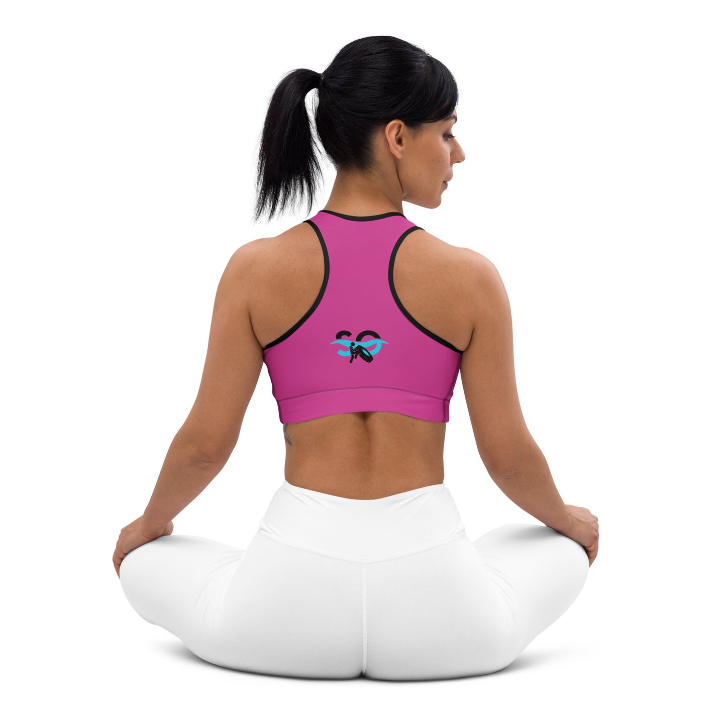 a woman in a pink sports bra top sitting in a yoga position