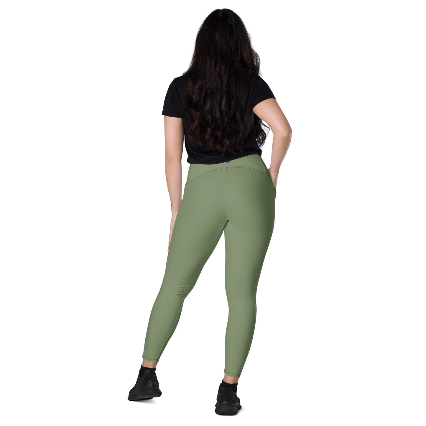 a woman in a black top and green leggings