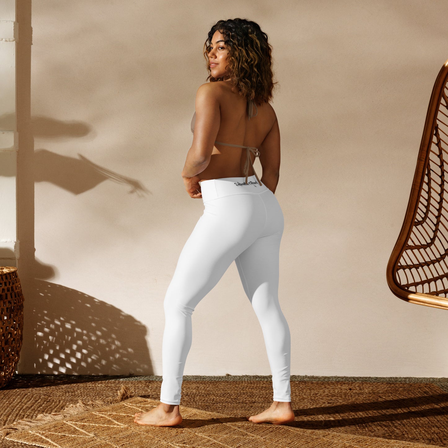 a woman in white pants standing in front of a wall