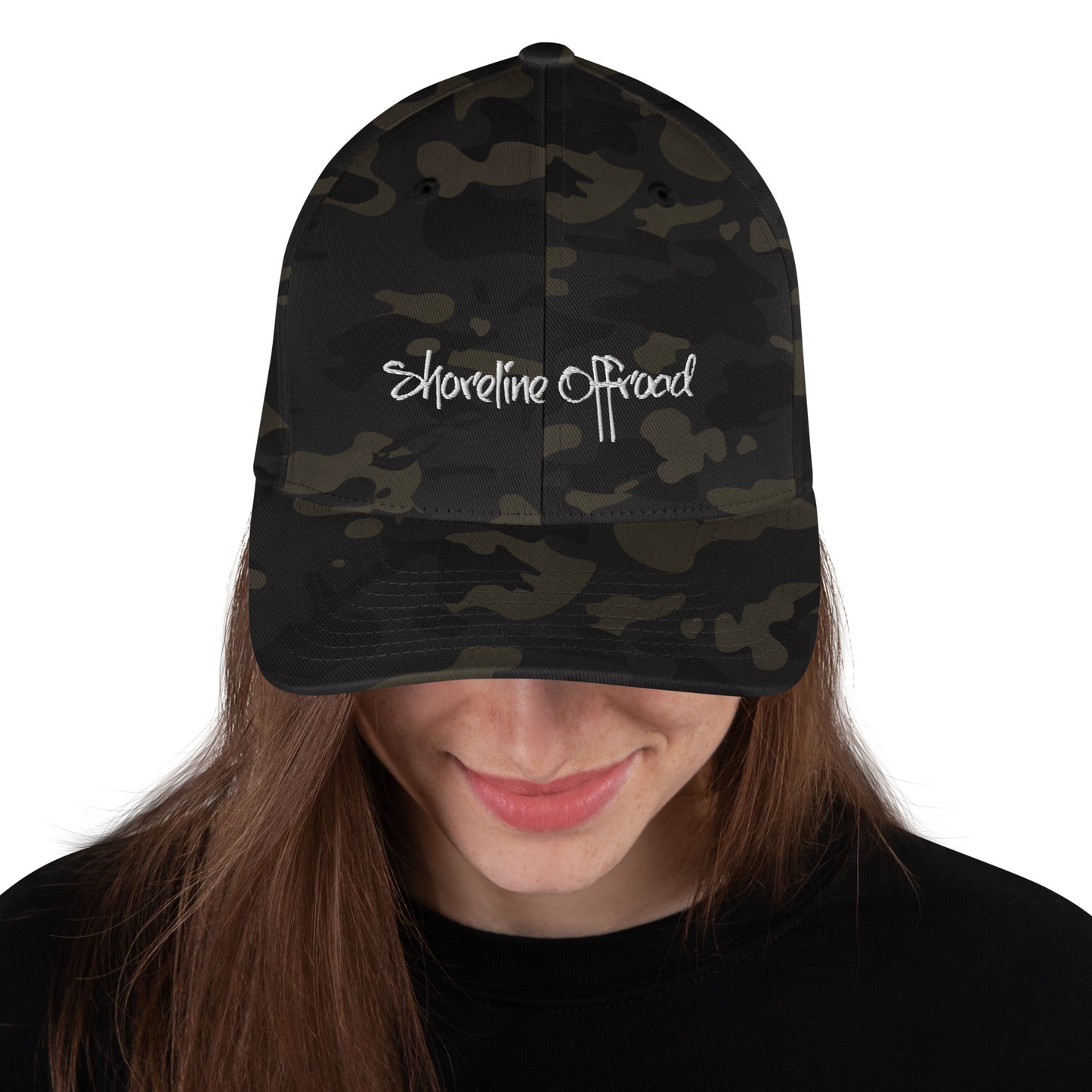 a woman wearing a camo hat with the words shoreline beach on it