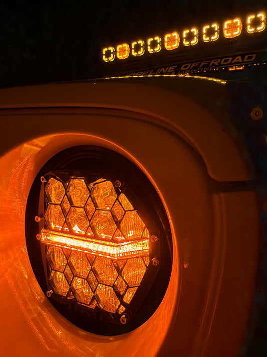 Hex6 Pro amber honeycomb headlight glowing in Jeep fender with amber roofline pods above