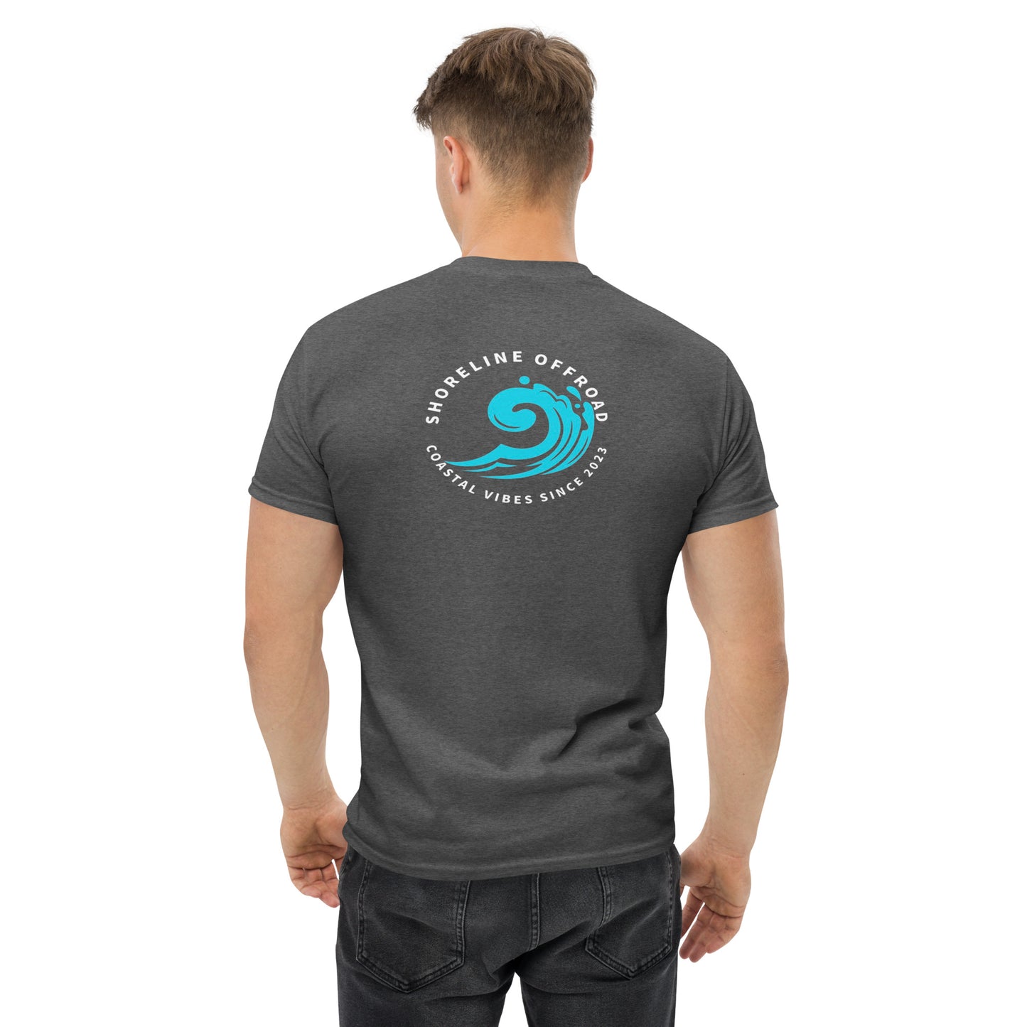 a man wearing a grey t - shirt with a blue wave on it