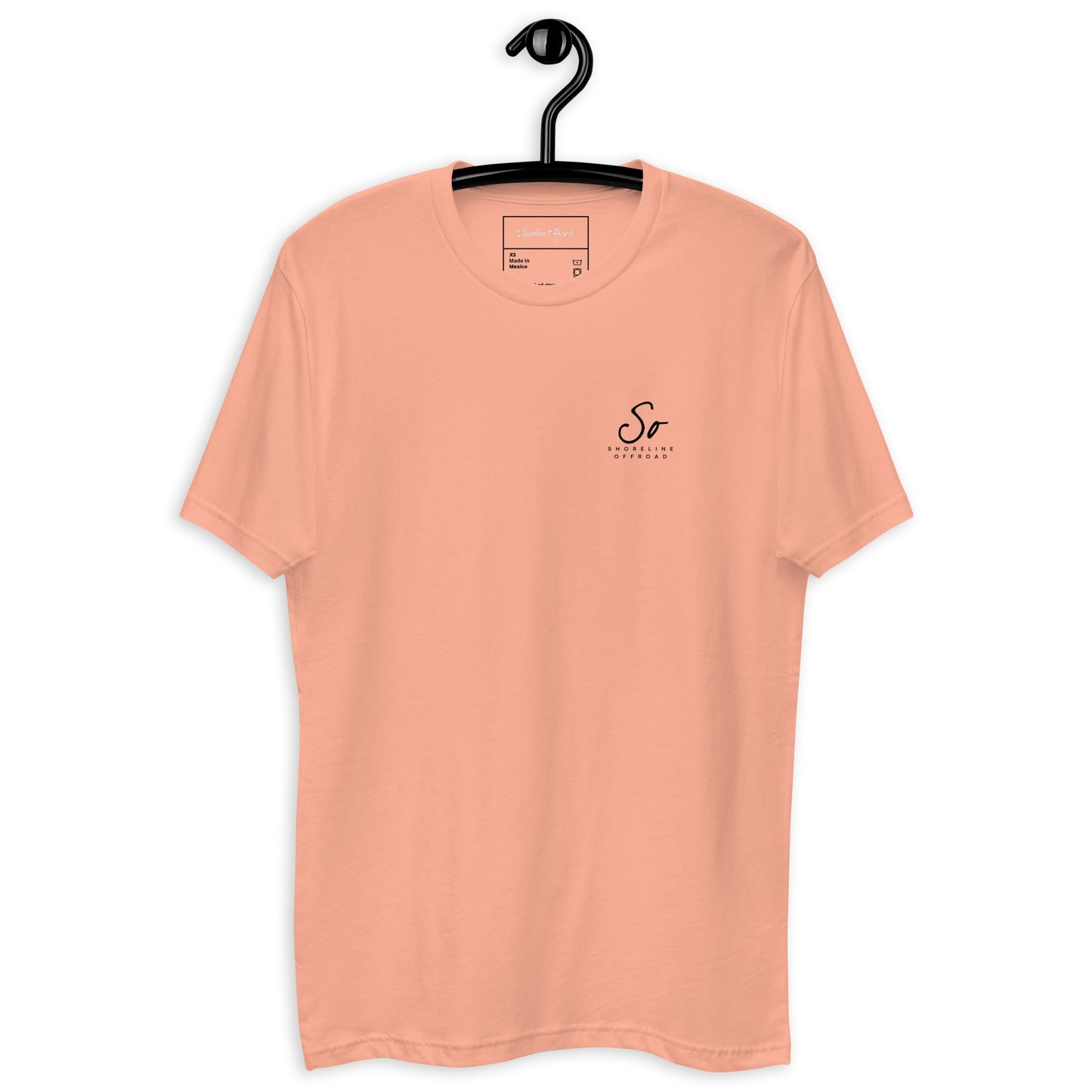 a t - shirt hanging on a hanger on a white wall