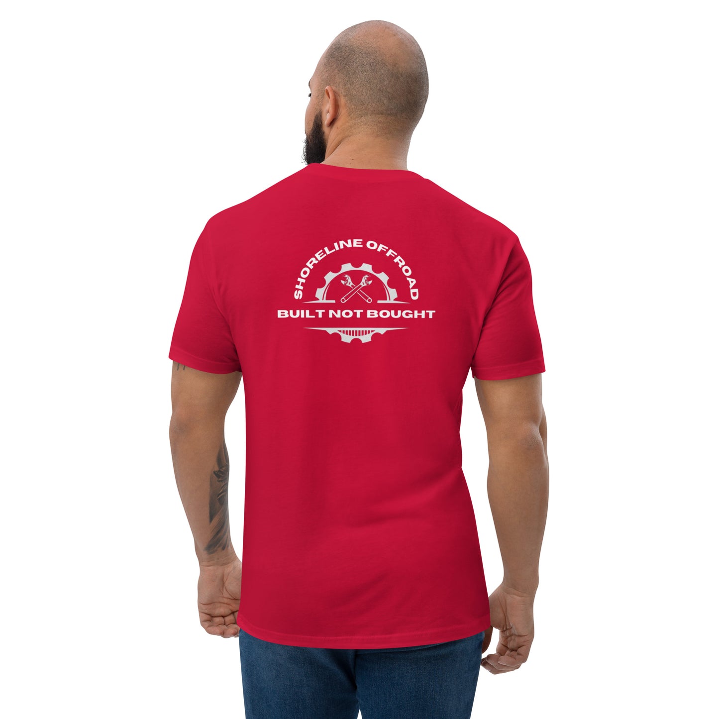 a man wearing a red t - shirt that says built not bought