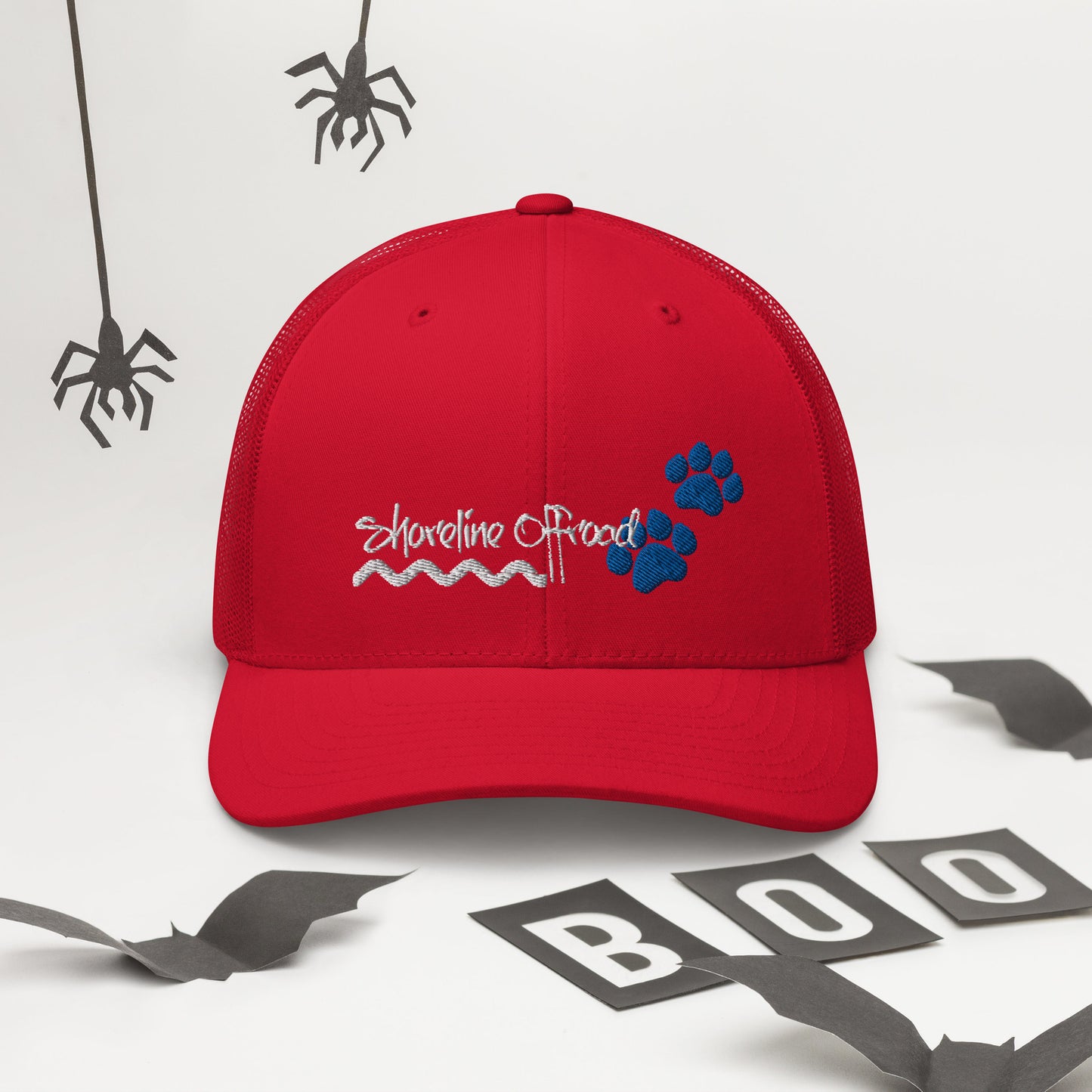 a red trucker hat with a blue dog paw on it