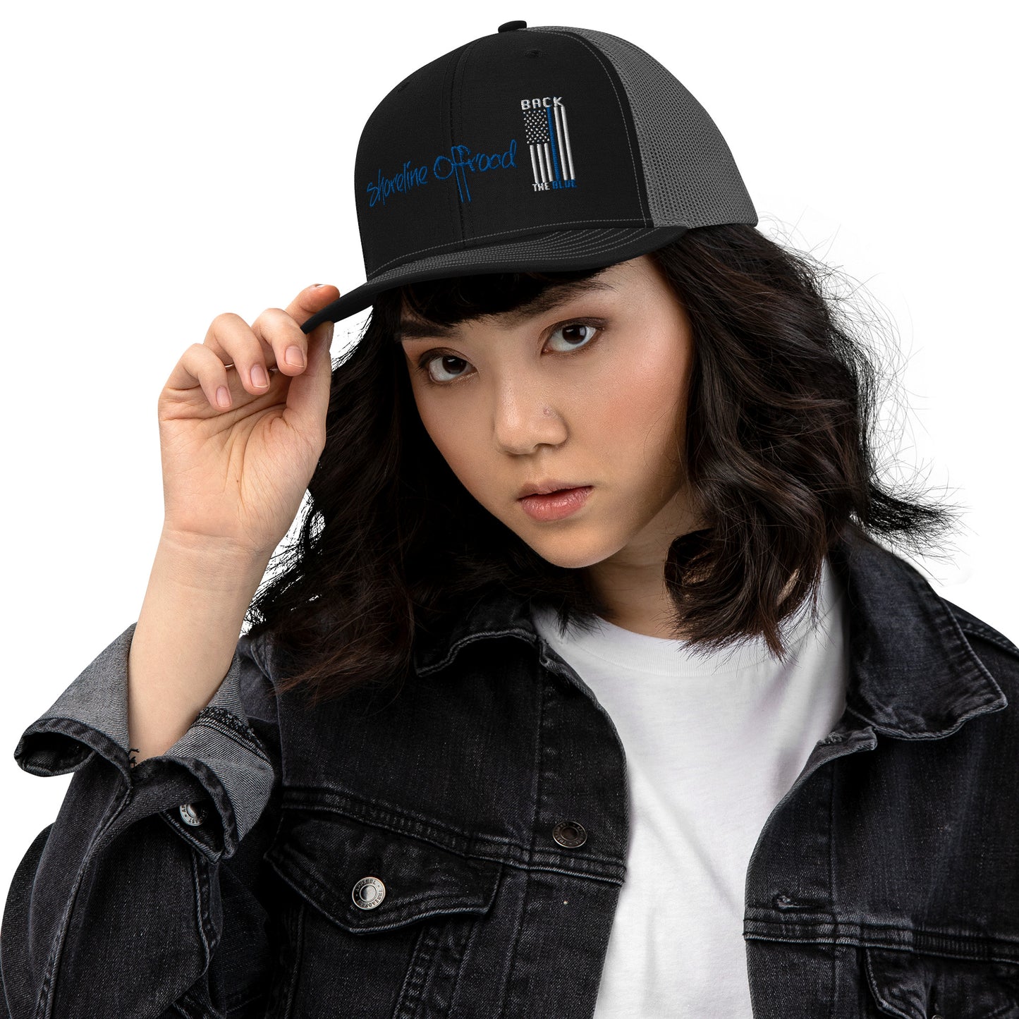 a woman wearing a black hat and denim jacket