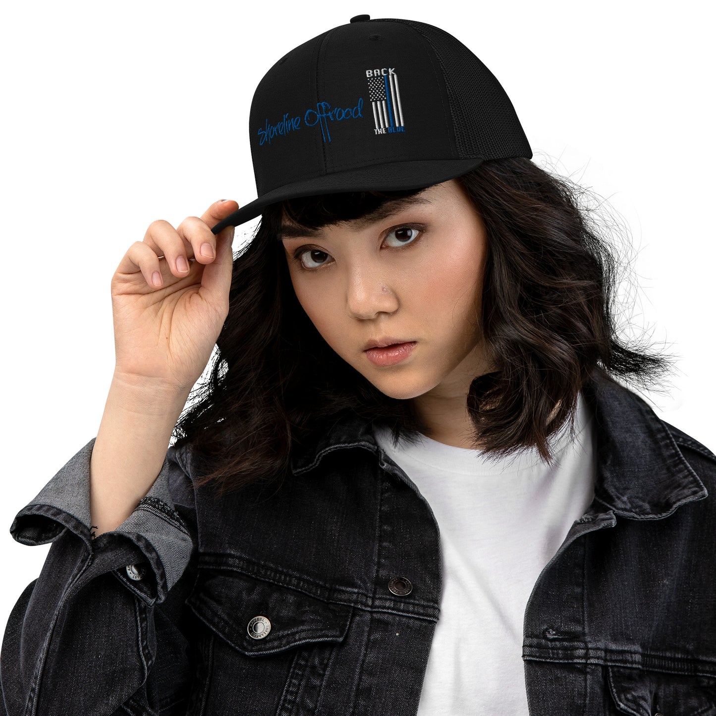 a woman wearing a black hat and denim jacket