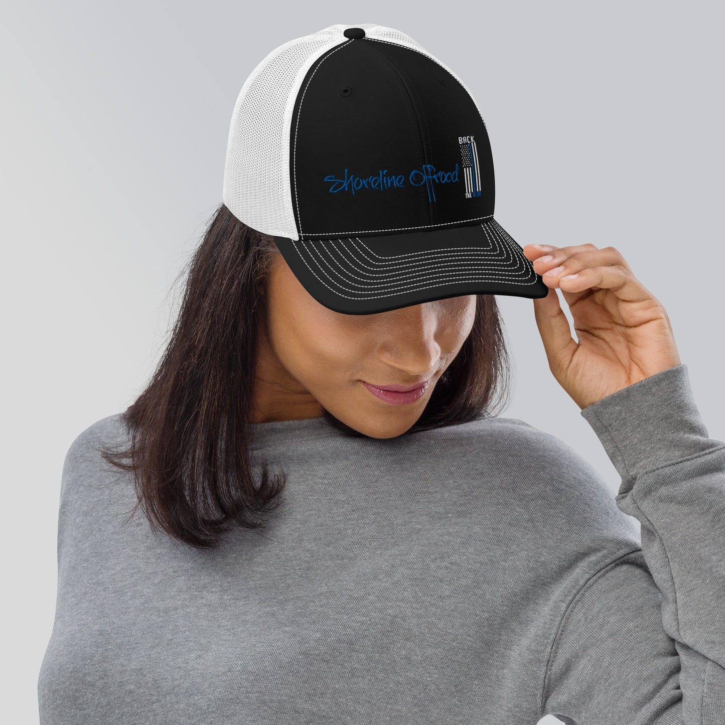 a woman wearing a black and white trucker hat