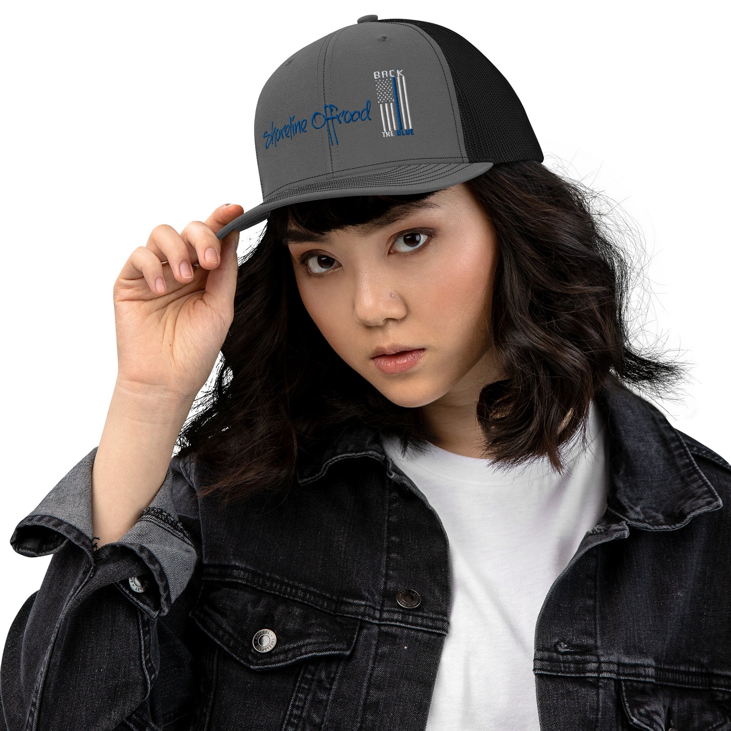 a woman in a denim jacket and a hat