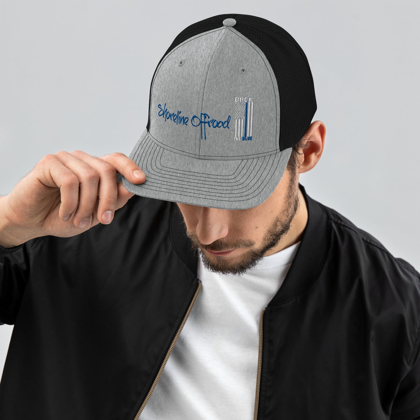 a man wearing a black and grey hat with a blue logo