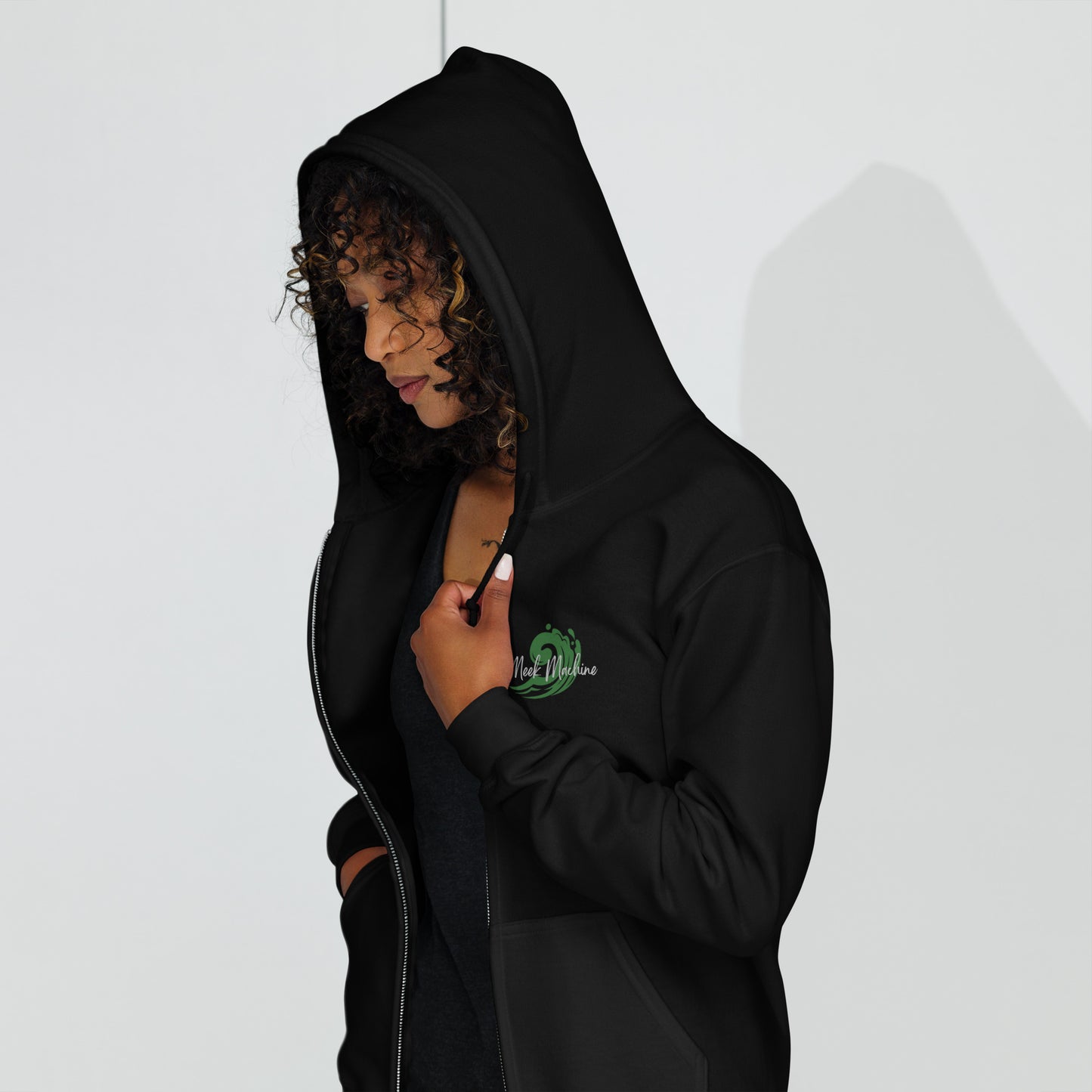a woman in a black hoodie is looking at her cell phone