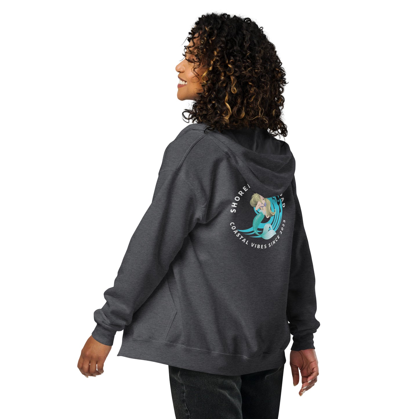 a woman with curly hair wearing a gray hoodie
