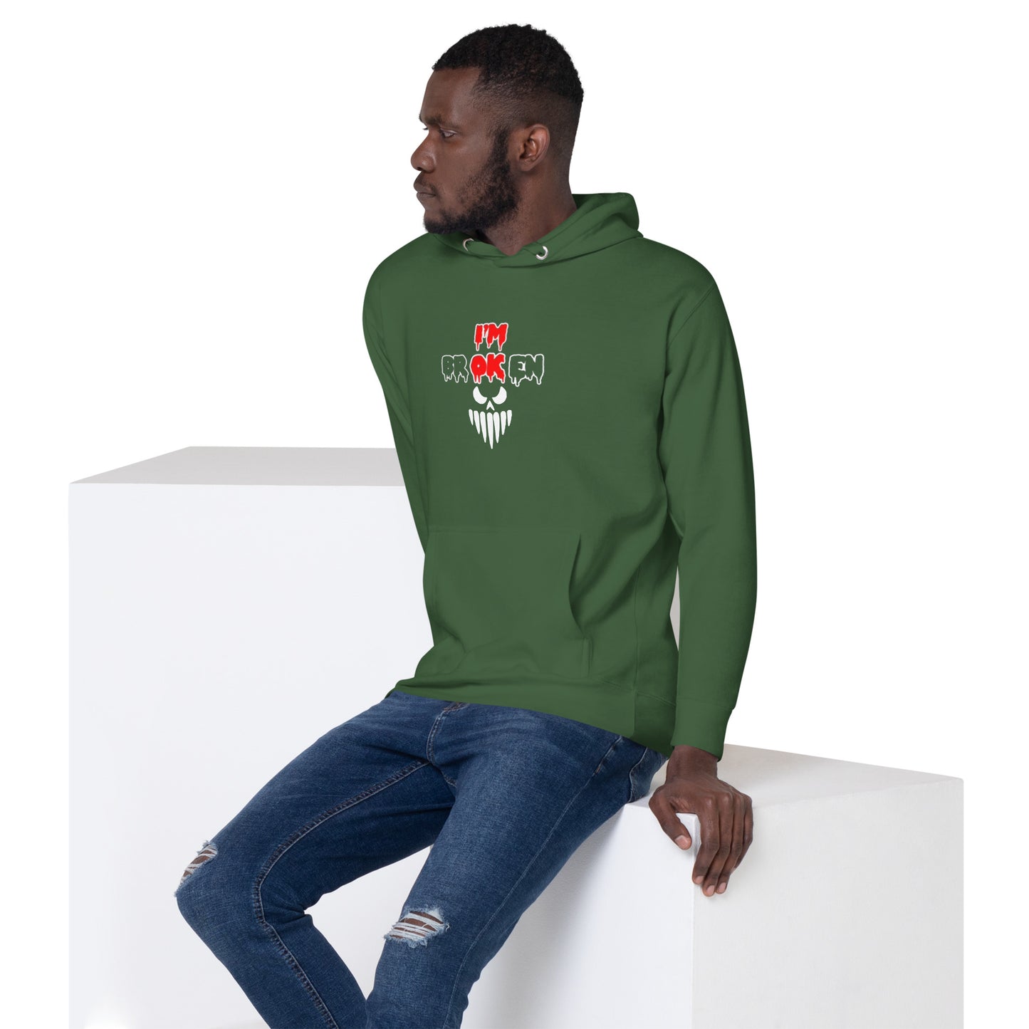 a man in a green hoodie sitting on a block