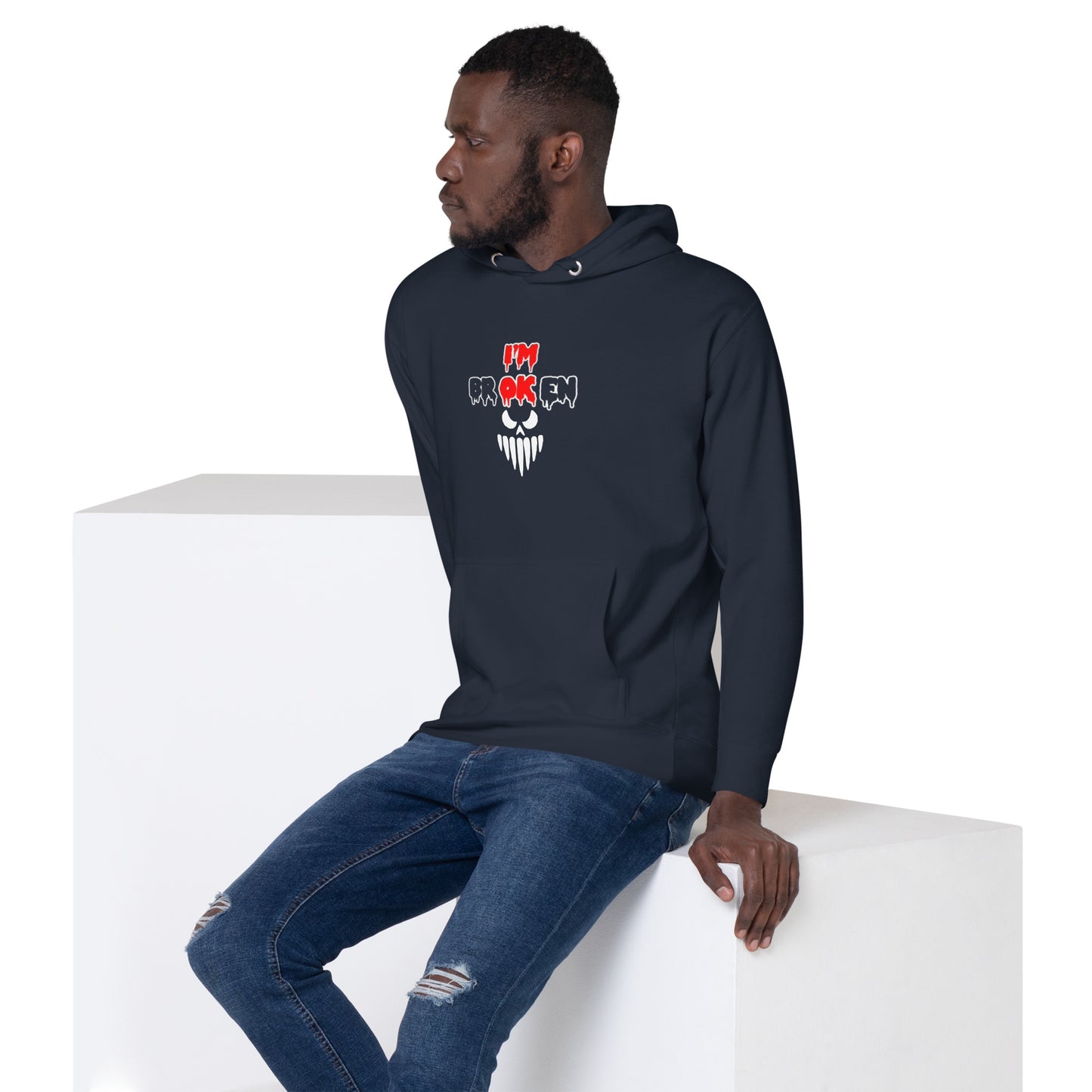 a man sitting on a block wearing a black hoodie