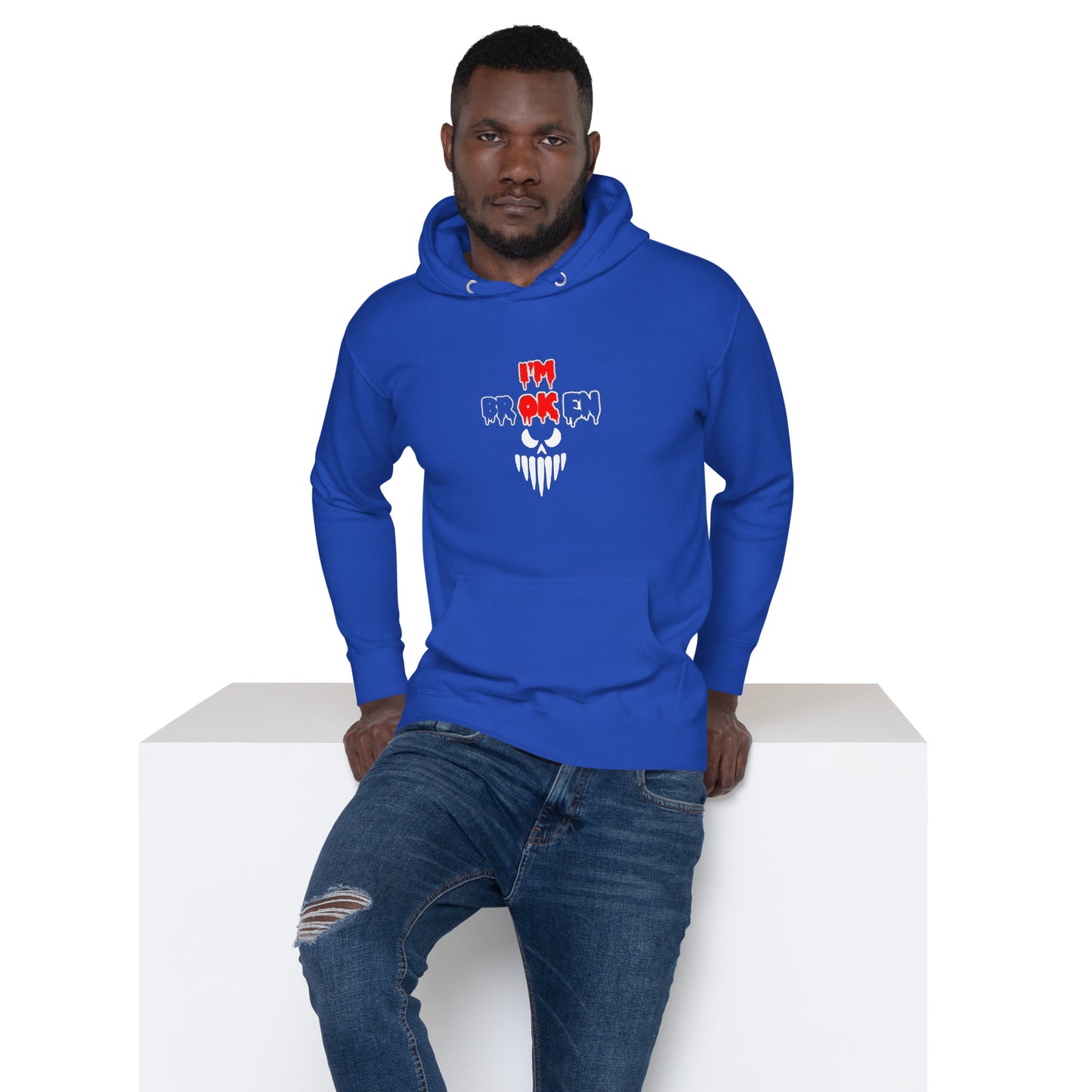 a man in a blue hoodie sitting on a white block