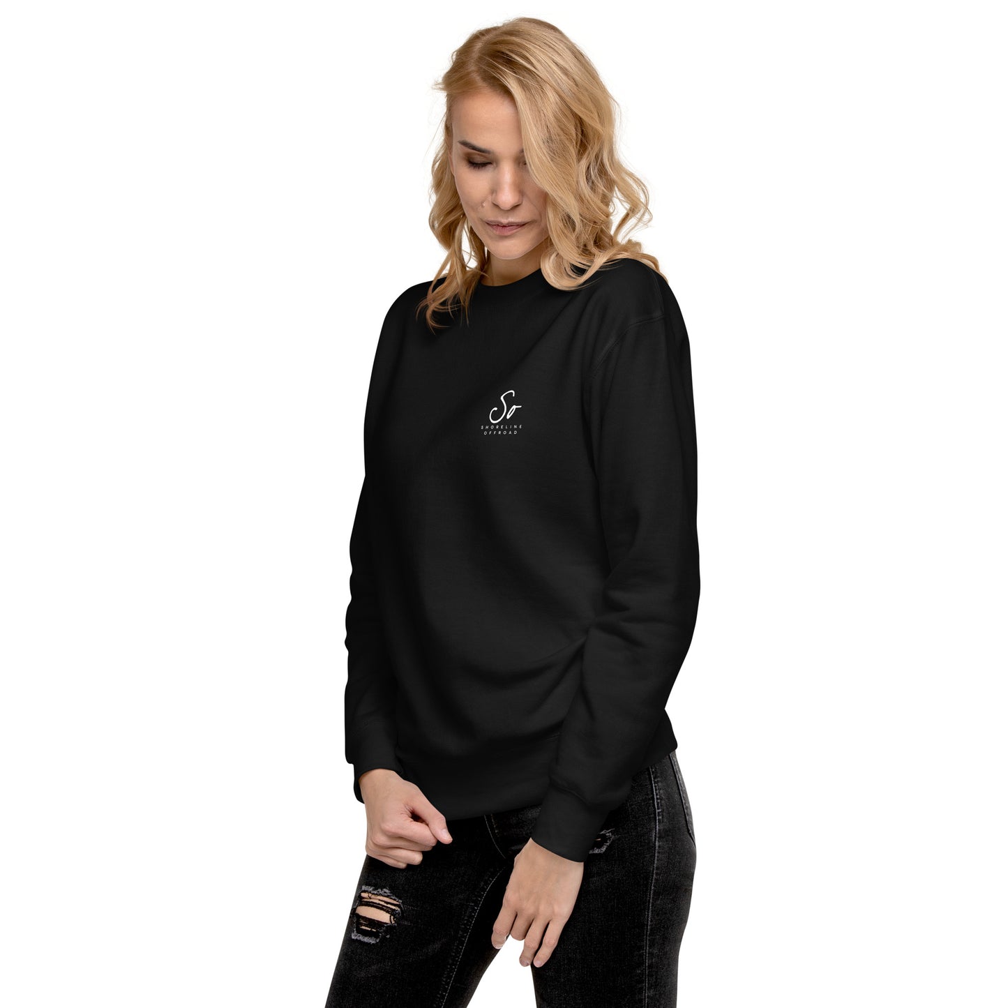 a woman wearing a black sweatshirt and ripped jeans