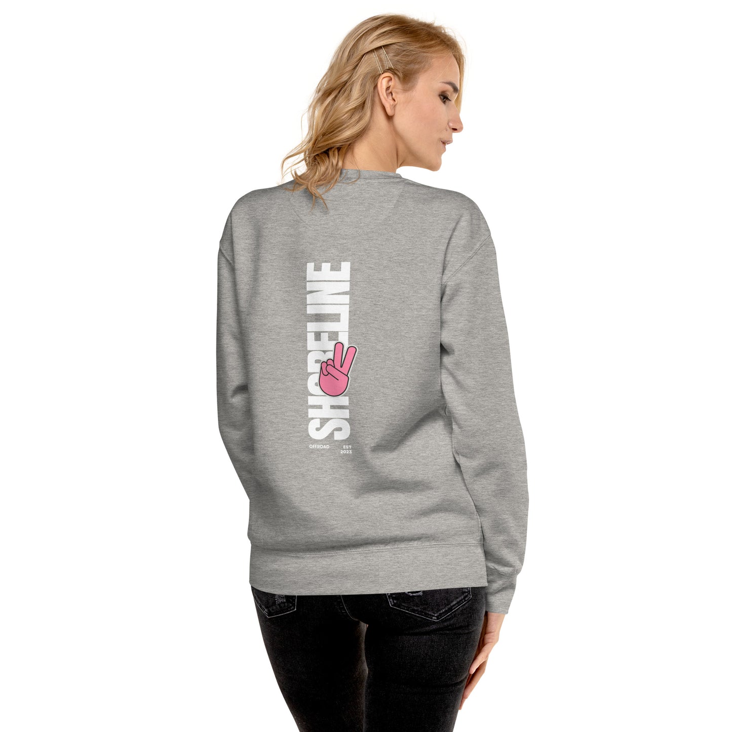 a woman wearing a grey sweatshirt with a pink peace sign on it