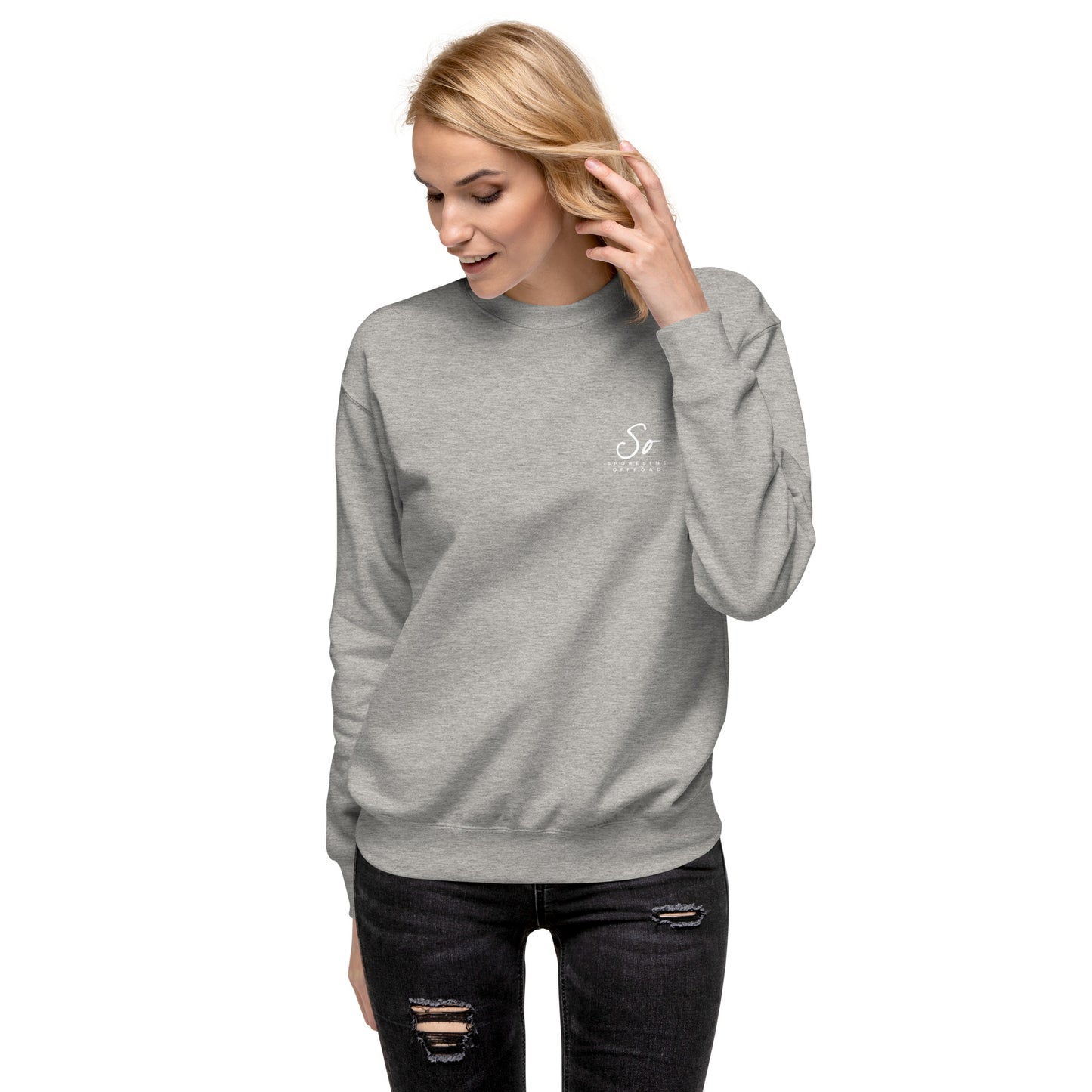 a woman wearing a grey sweatshirt and ripped jeans