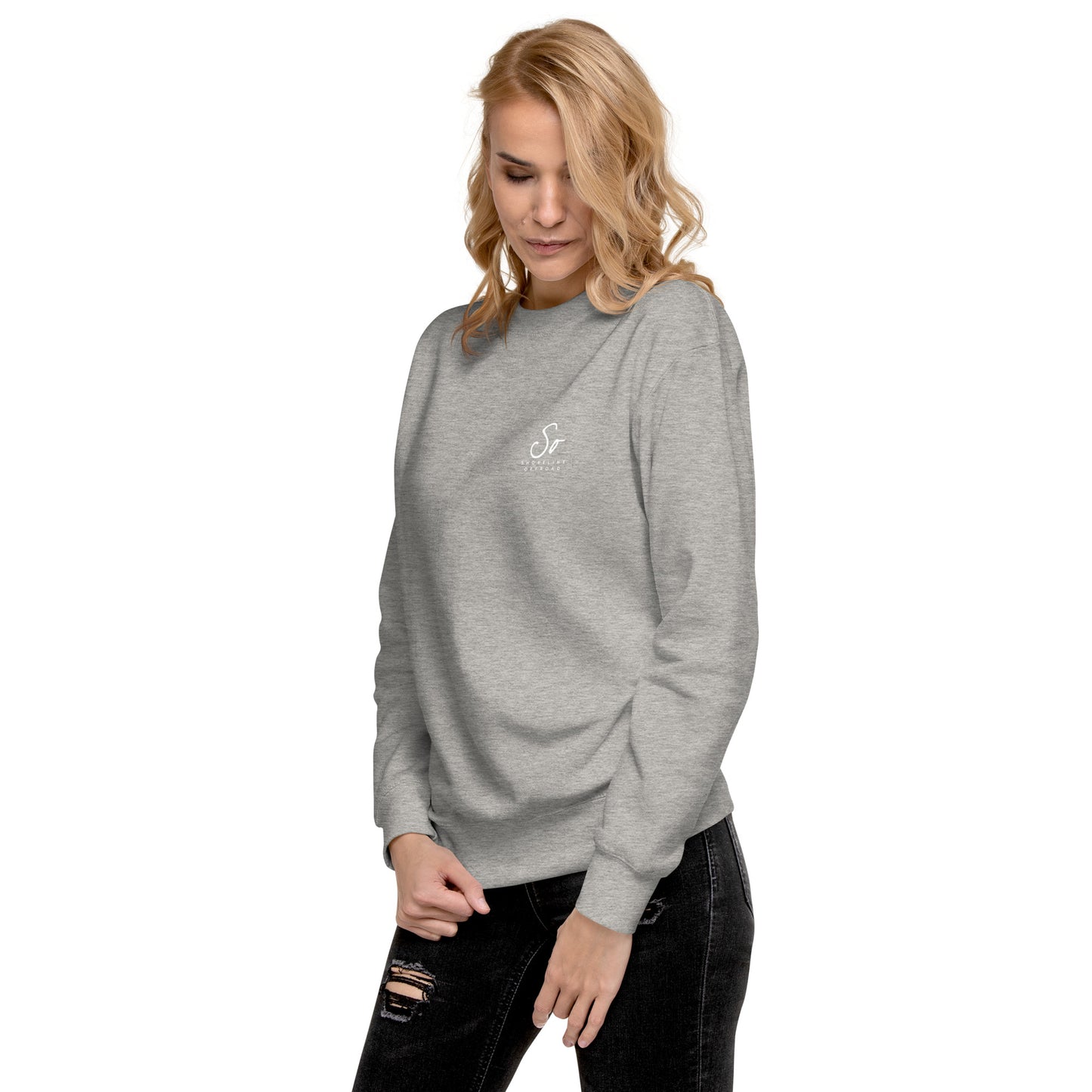 a woman wearing a grey sweatshirt and ripped jeans