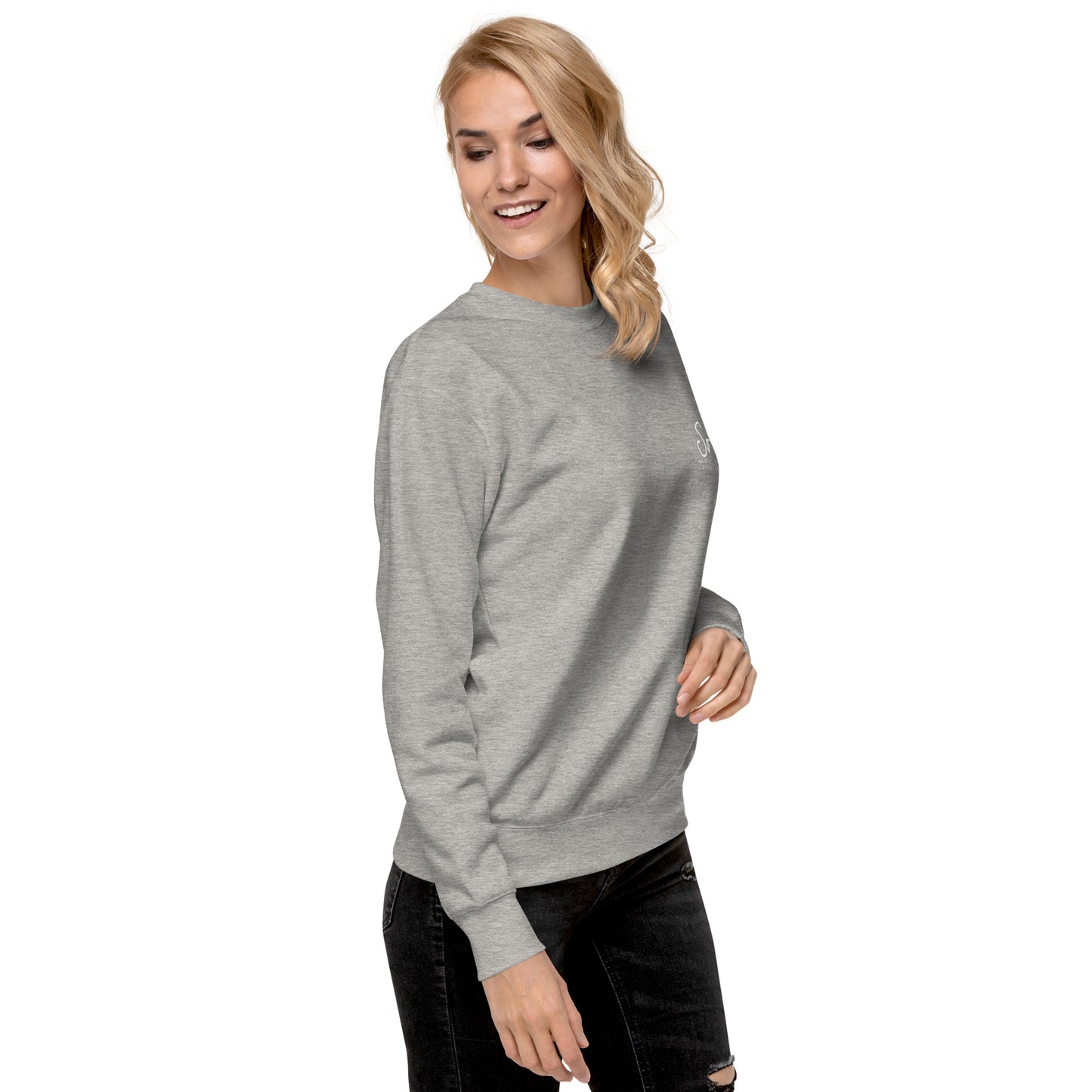 a woman wearing a grey sweatshirt and ripped jeans