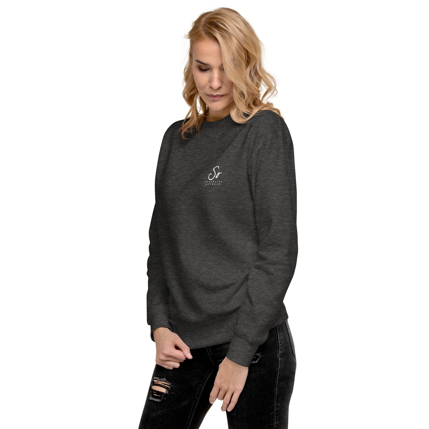 a woman wearing a black sweatshirt and ripped jeans