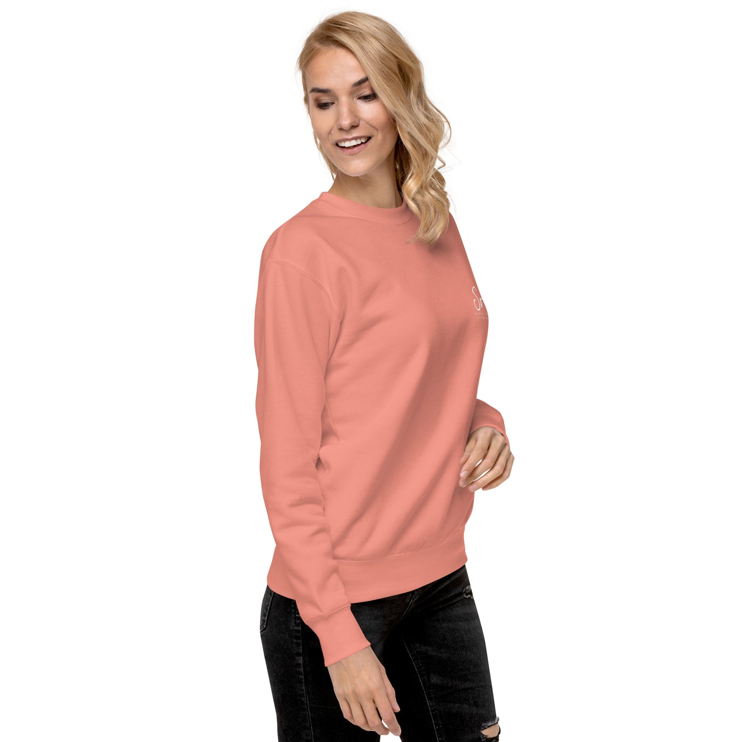 a woman wearing a pink sweatshirt and ripped jeans