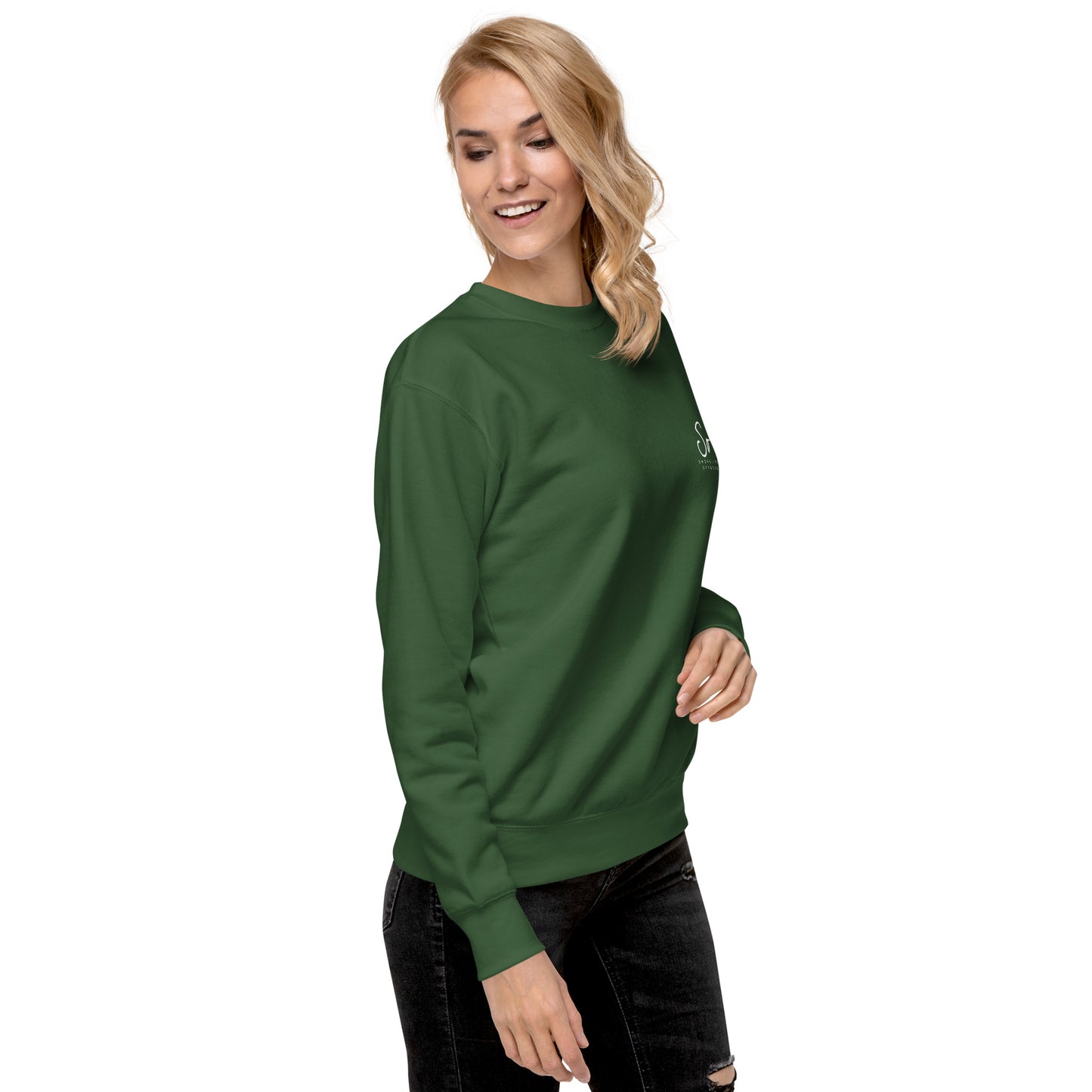 a woman wearing a green sweatshirt and ripped jeans