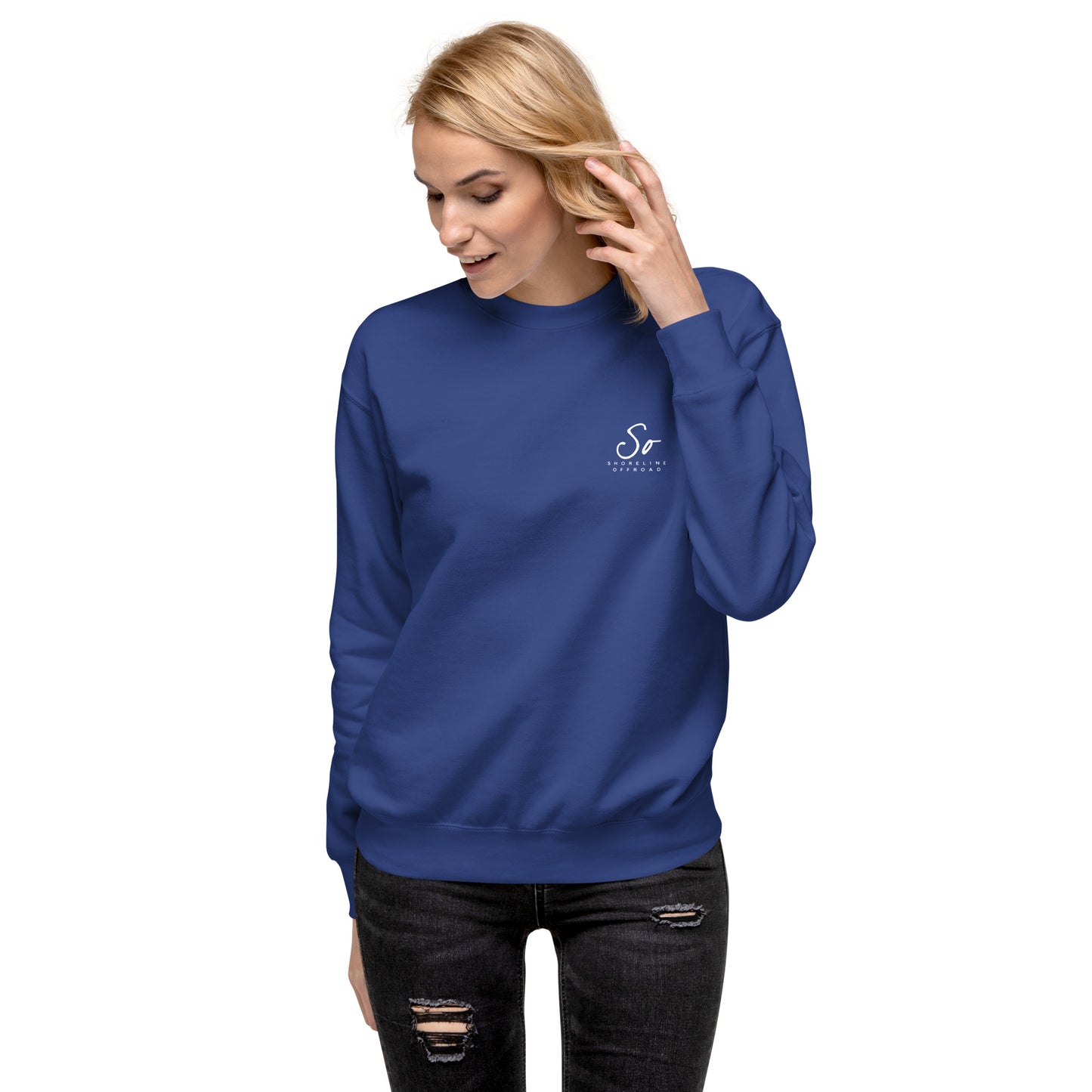 a woman wearing a blue sweatshirt and ripped jeans