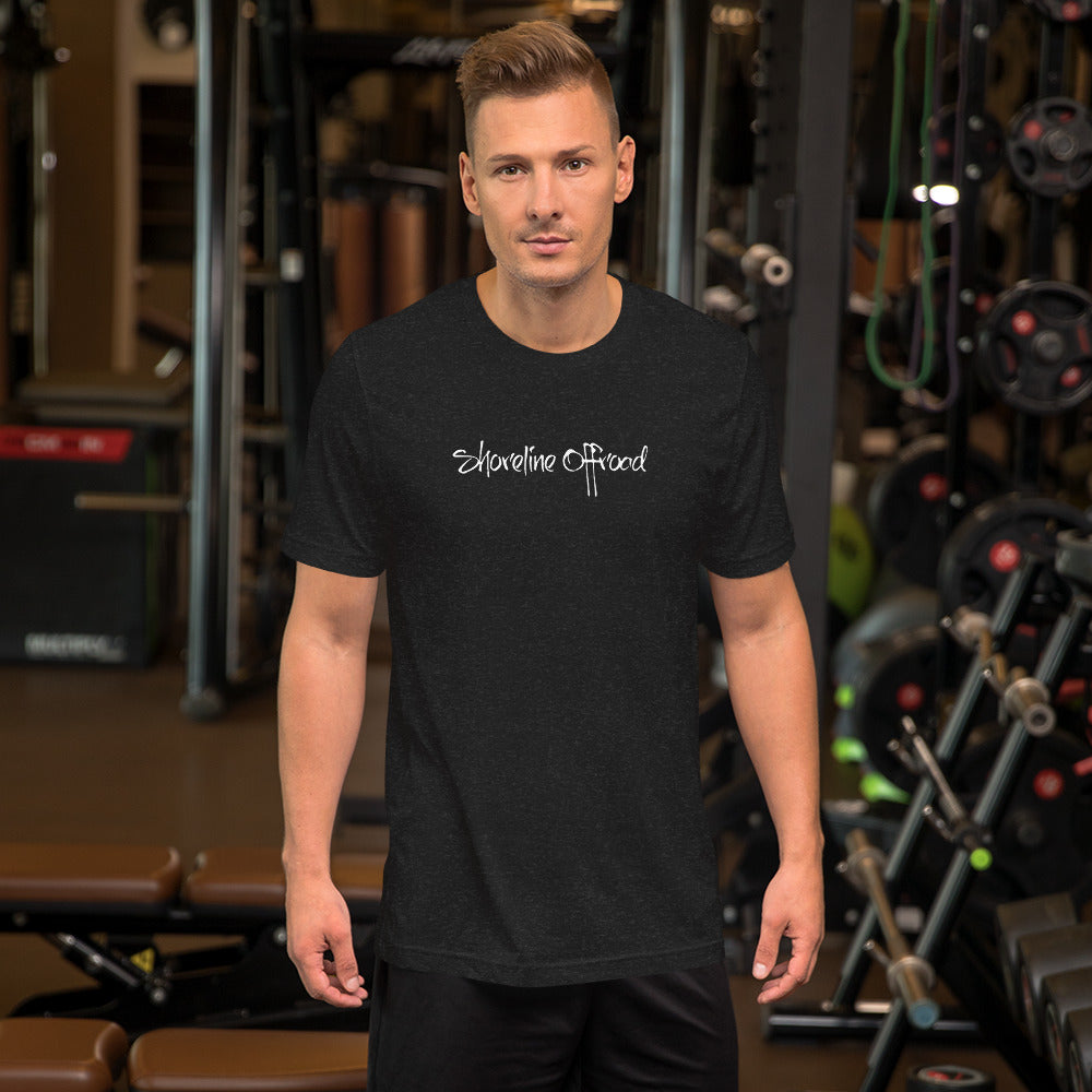 a man standing in a gym wearing a black shirt