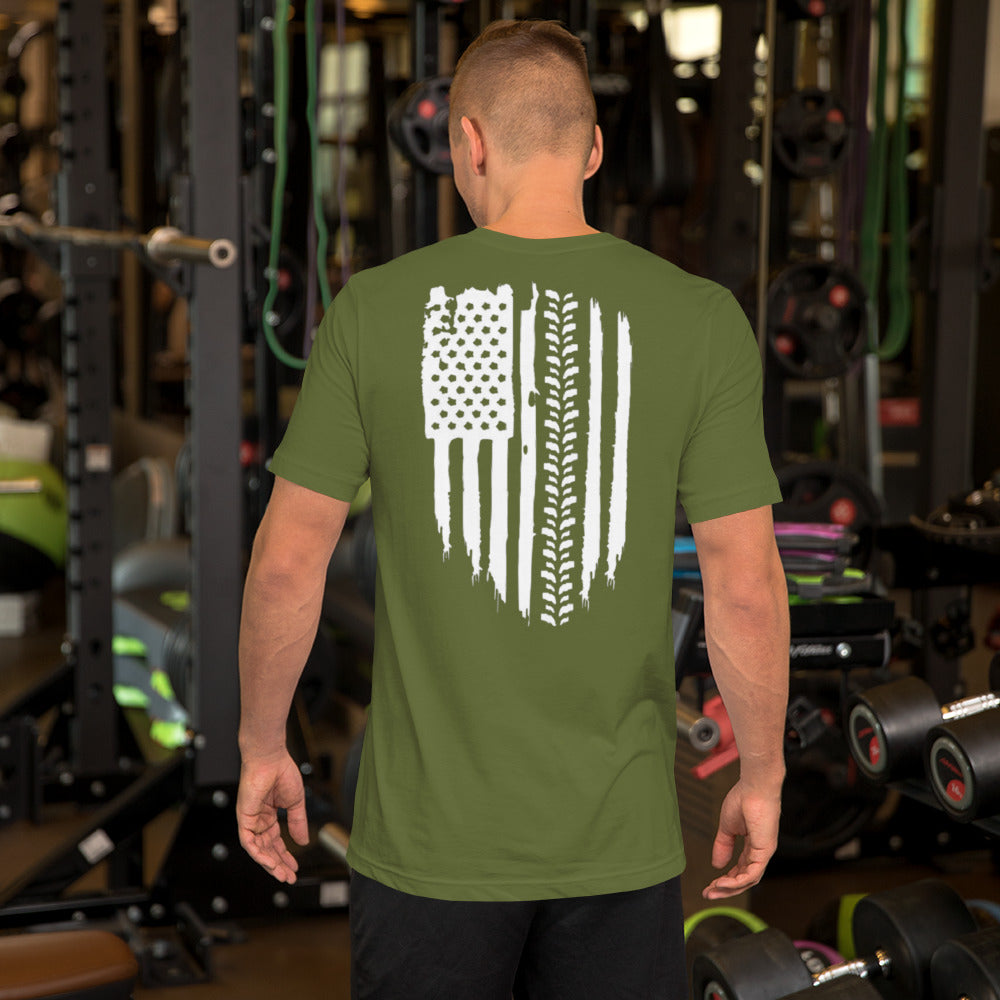 a man standing in a gym wearing a green t - shirt with an american flag