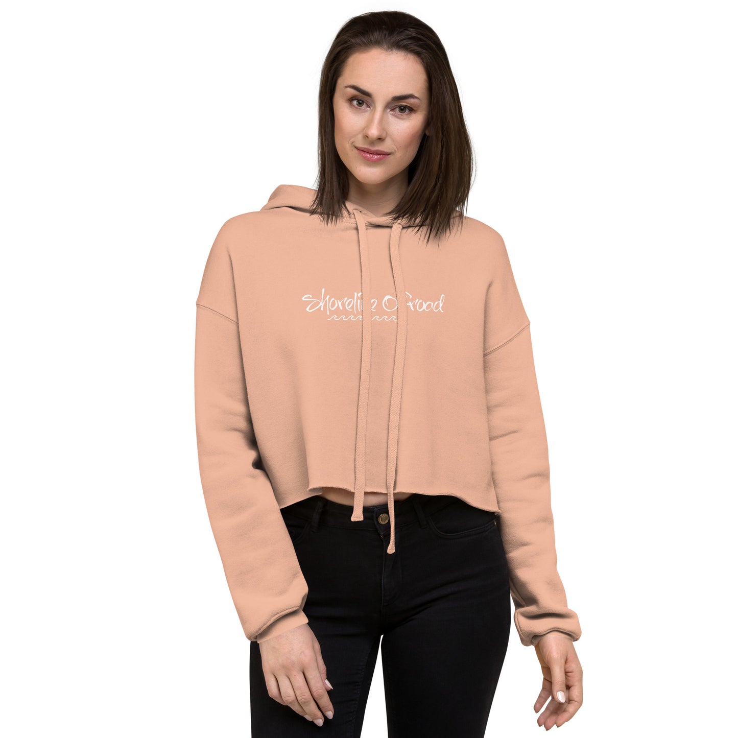 a woman wearing a pink cropped hoodie with a white slogan on it