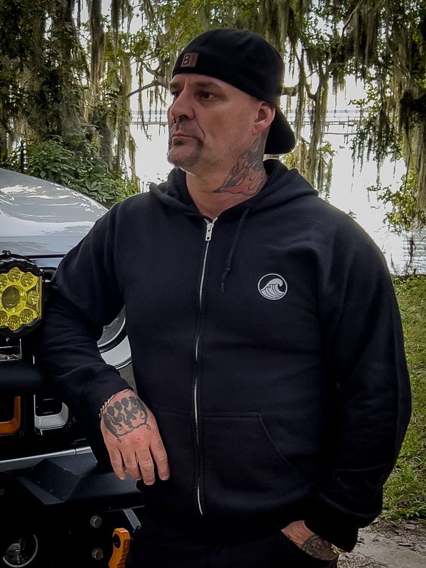 a man with tattoos standing next to a car