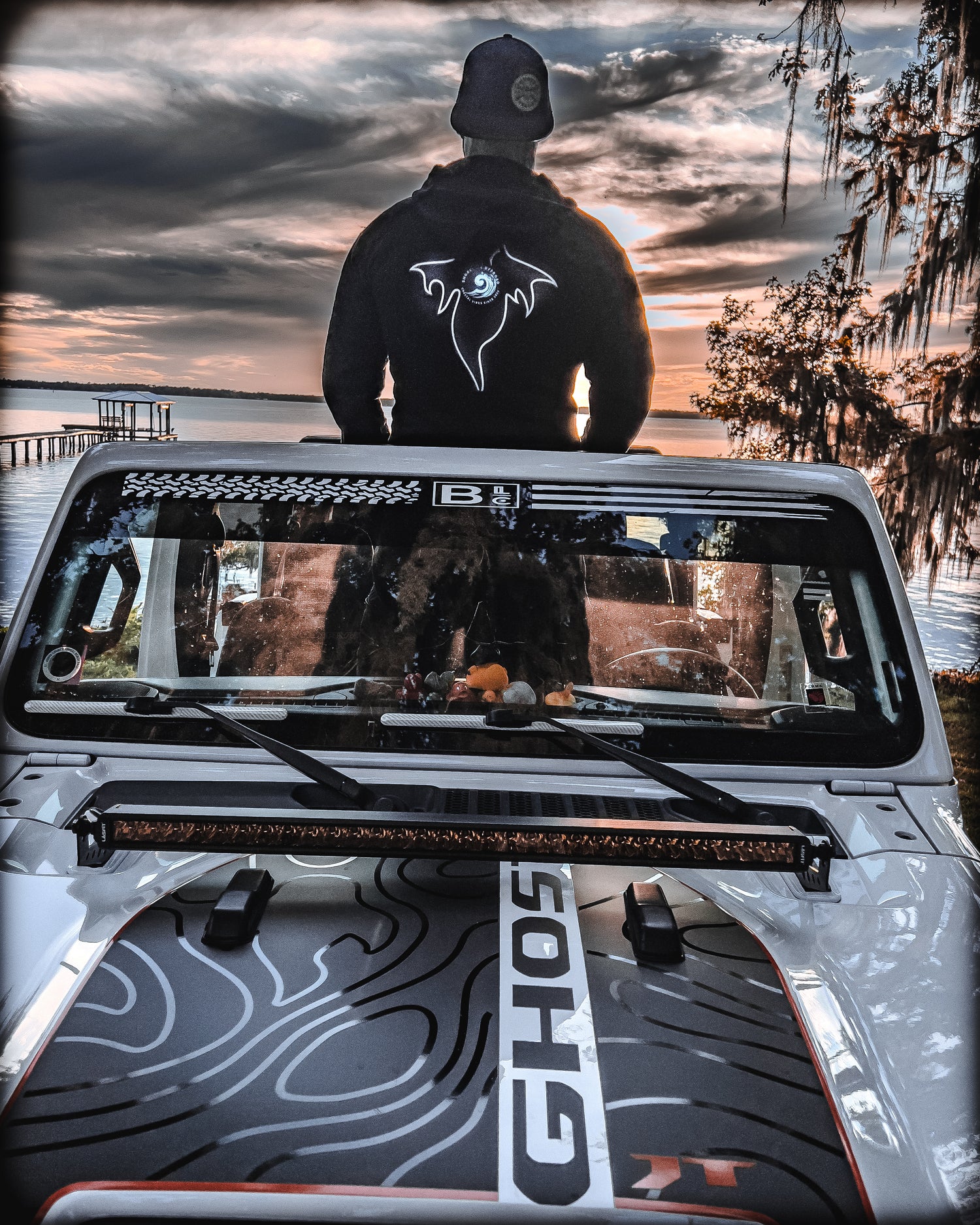 a man standing on top of a white jeep