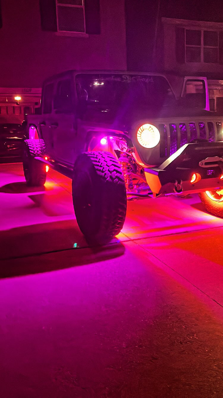 a jeep parked on the side of the road with its lights on