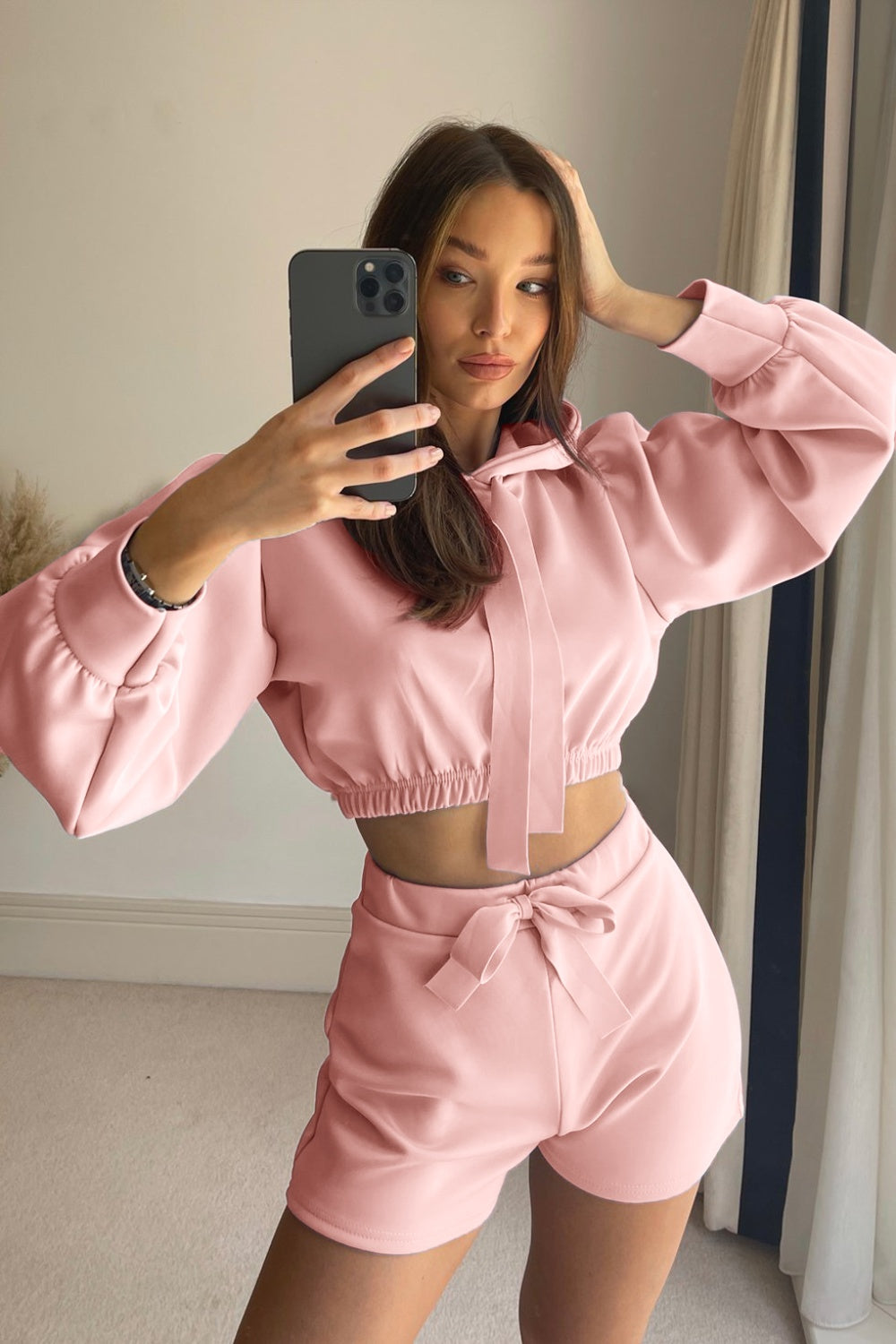 a woman taking a selfie in a pink outfit