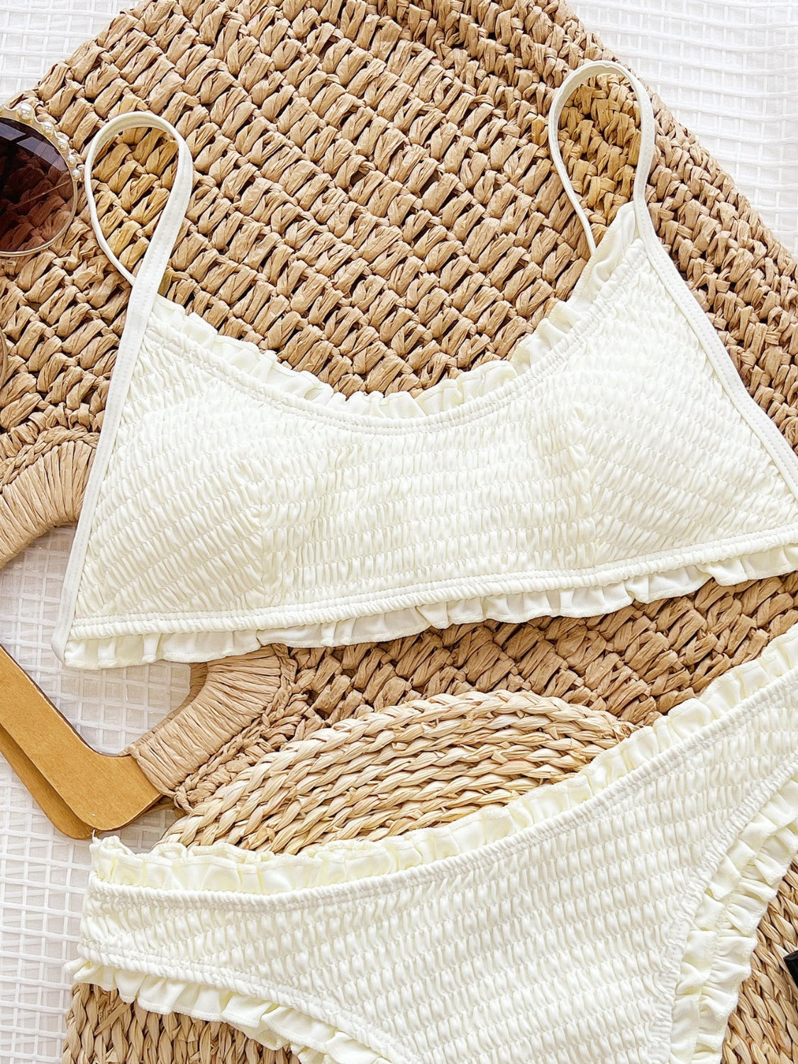 a bikini top and sunglasses laying on a mat