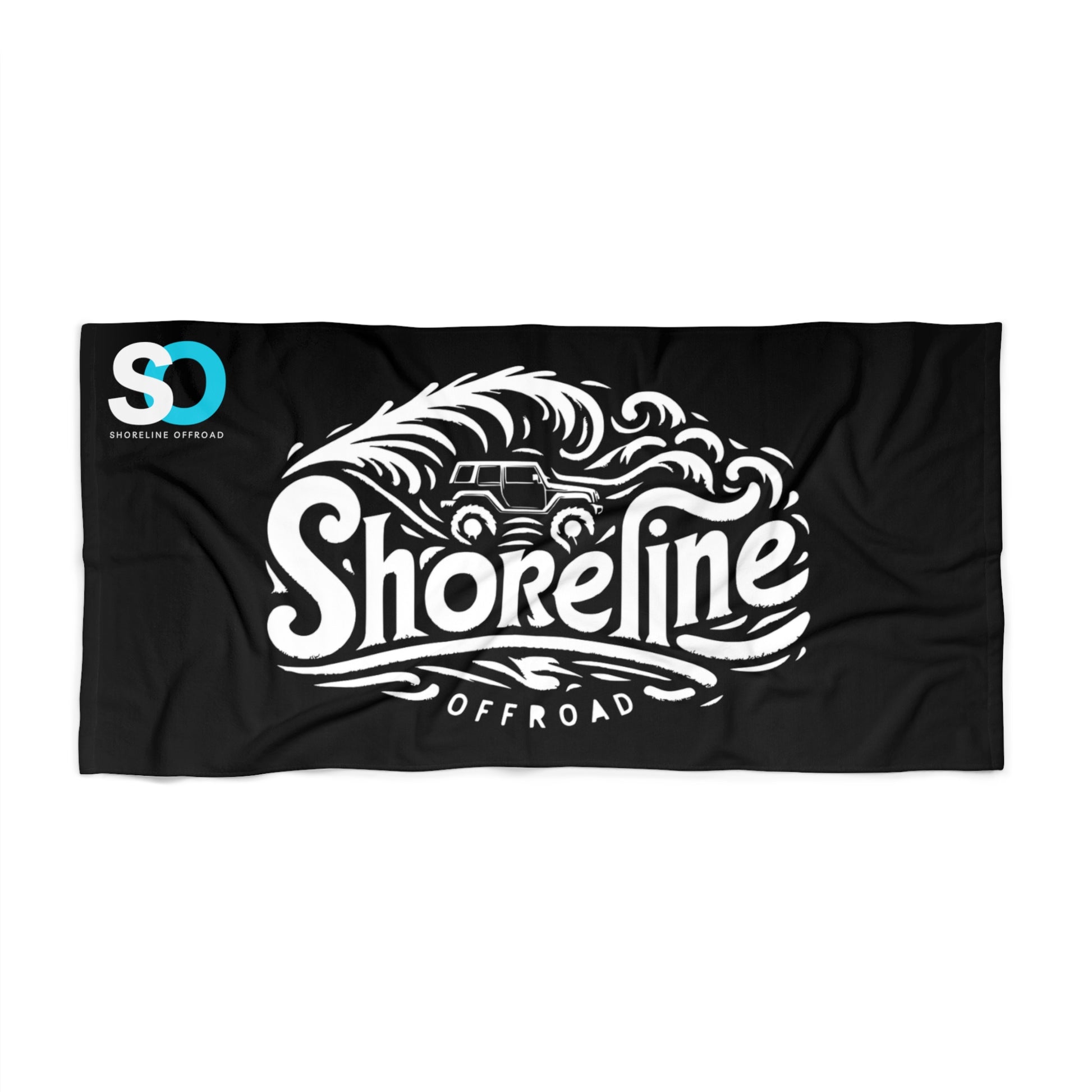 a black beach towel with the shoreline logo on it