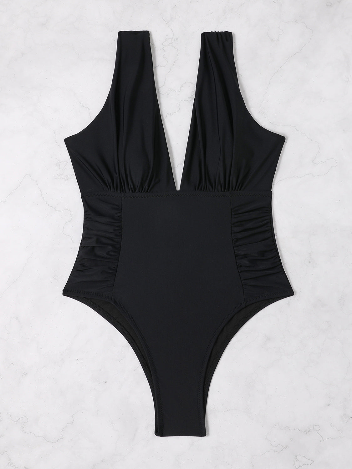 a black one piece swimsuit on a marble background