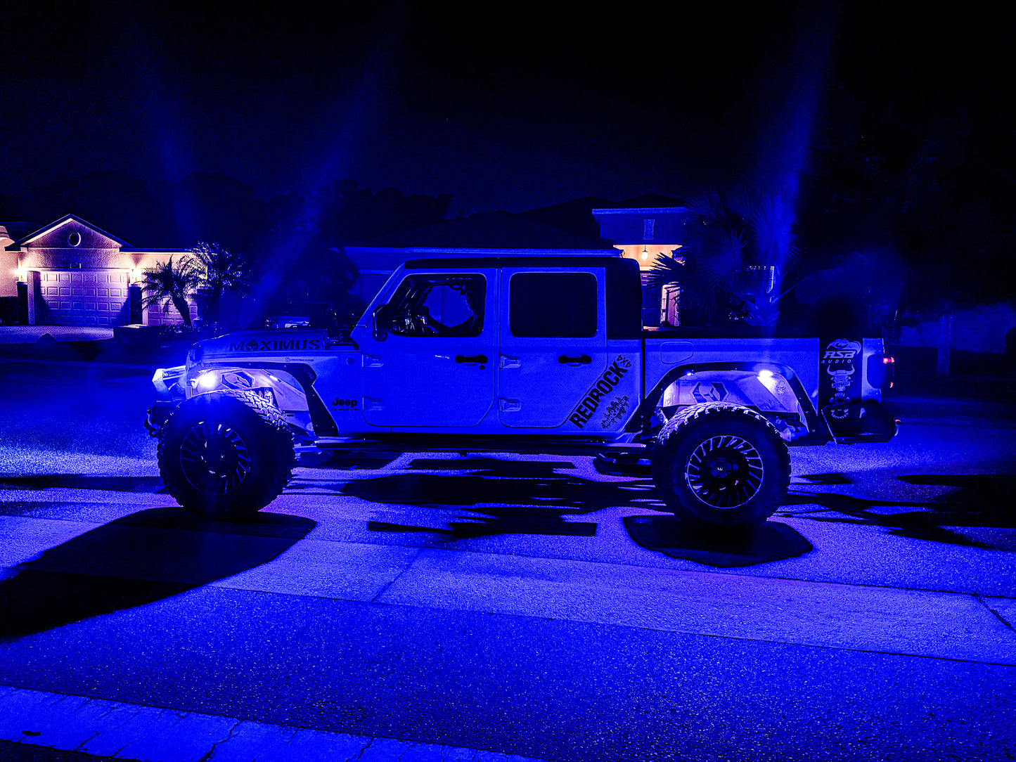 two jeeps parked in front of a house at night