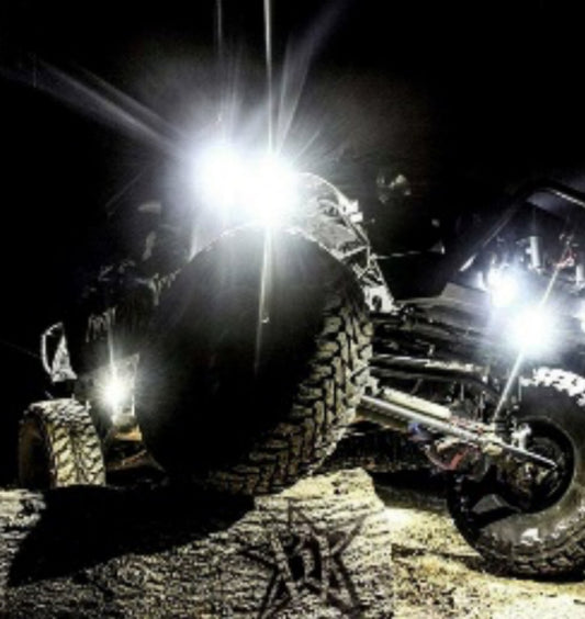 a pair of off road vehicles driving through the night