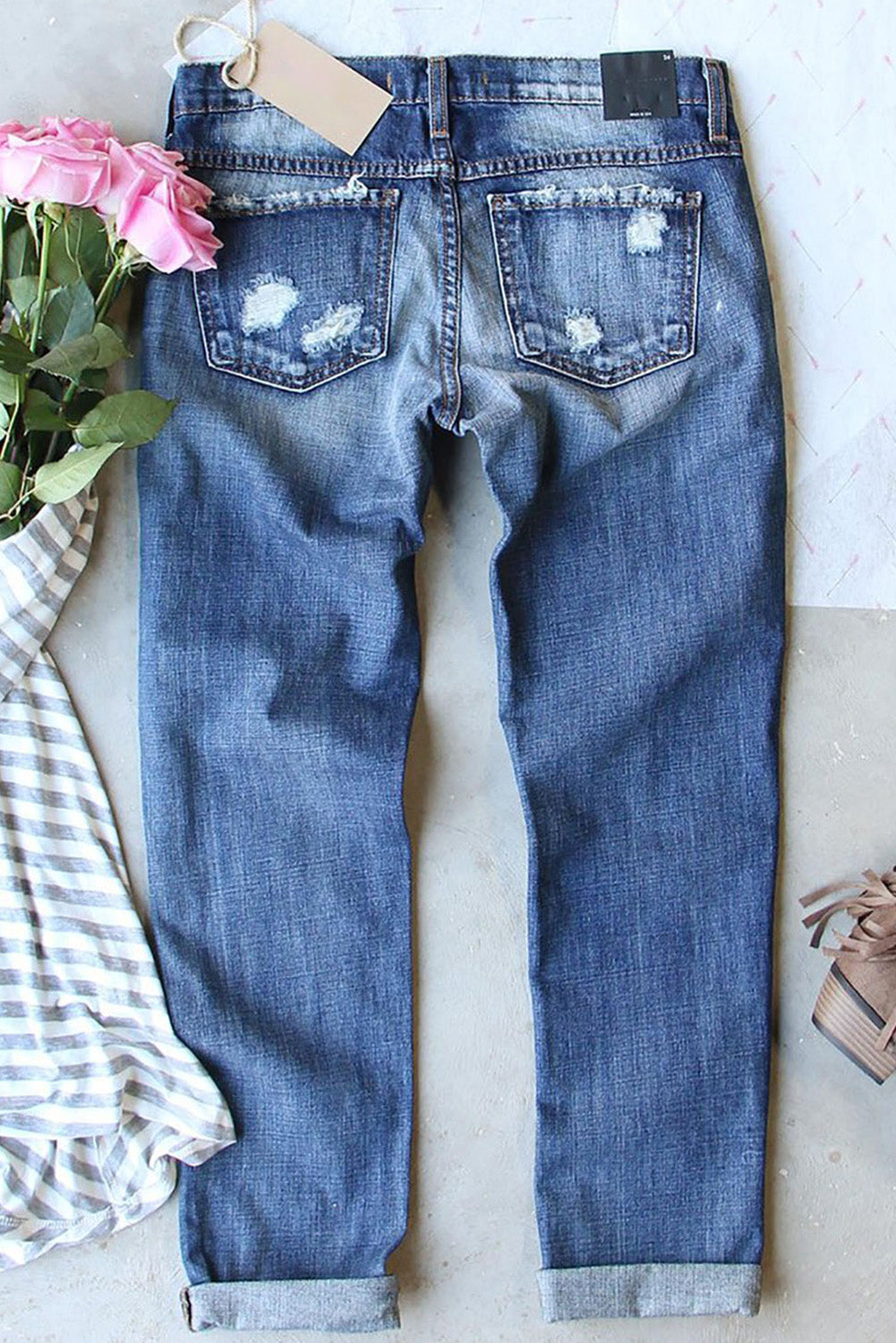 a pair of jeans with a flower and a tag