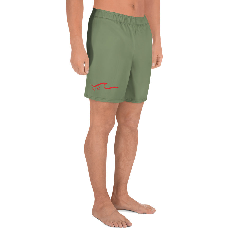 a man wearing a green shorts with a red wave on it