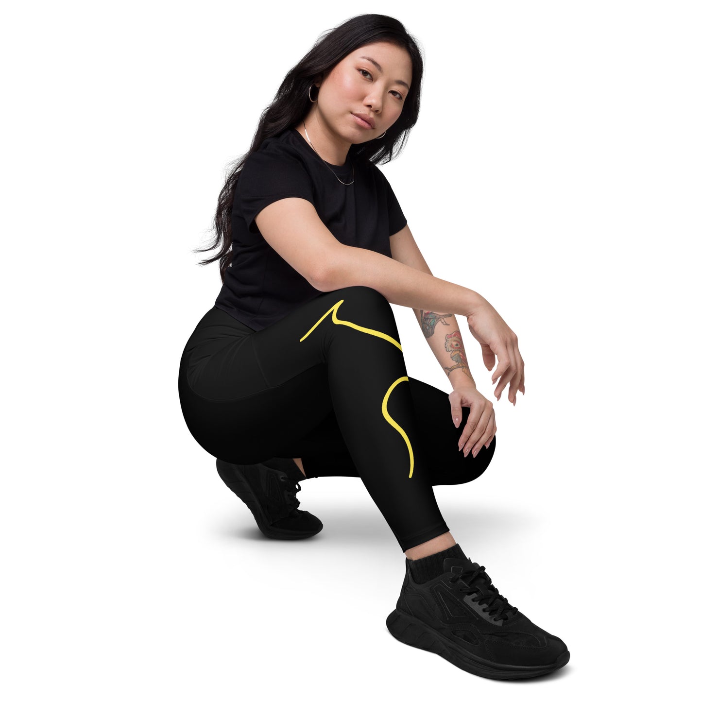 a woman squatting on the ground wearing black and yellow leggings