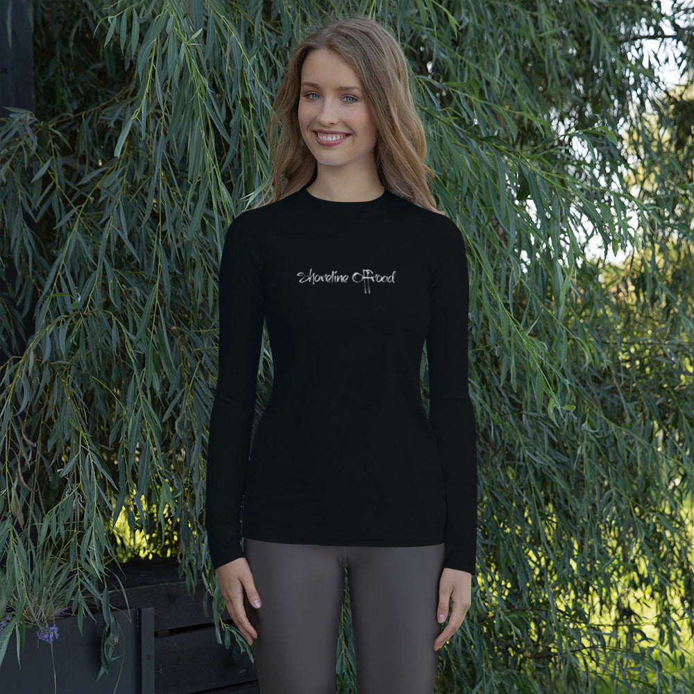 a woman standing in front of a tree wearing a black shirt