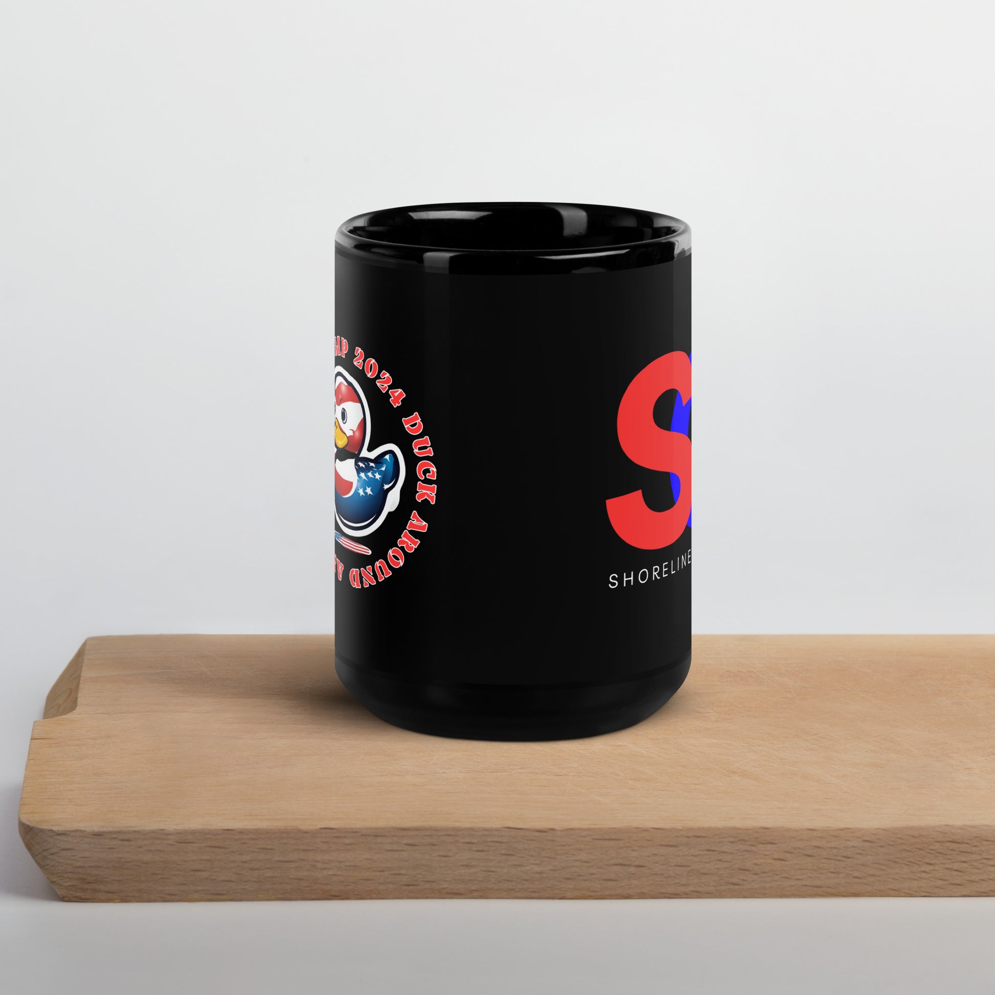 a black coffee mug sitting on top of a wooden table