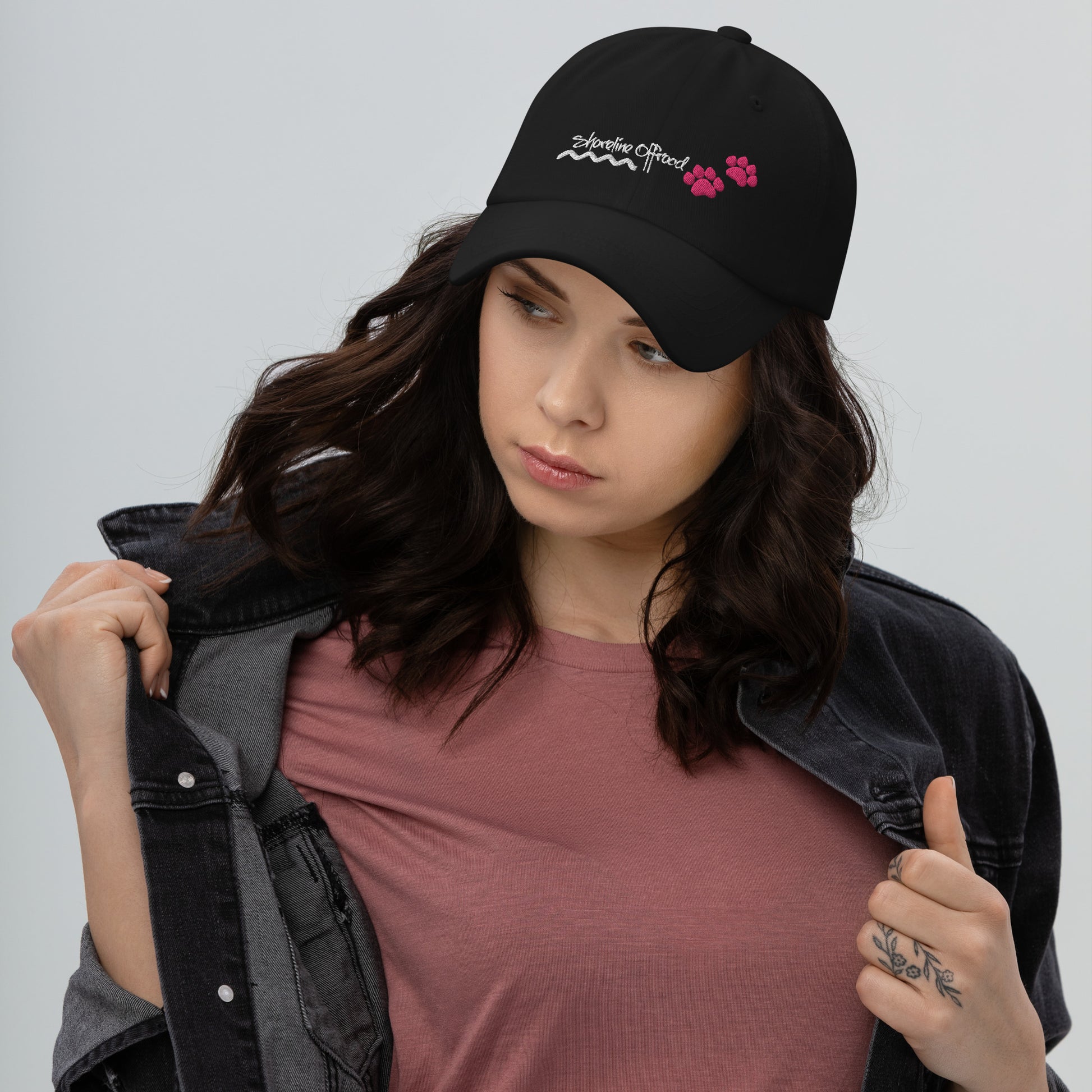 a woman wearing a black hat with pink flowers on it