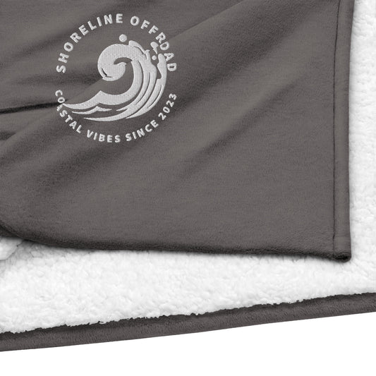 a towel with a logo on it laying on top of a blanket