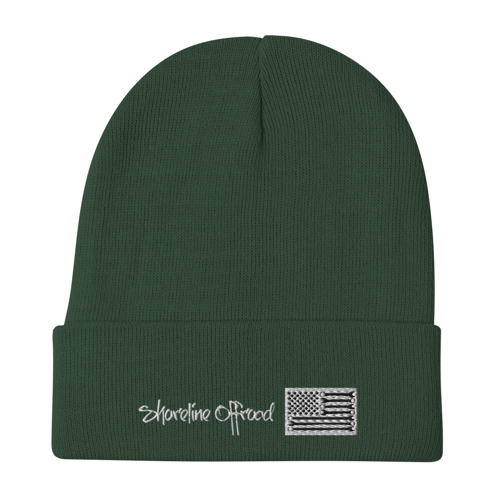 a green beanie with a white embroidered flag on it